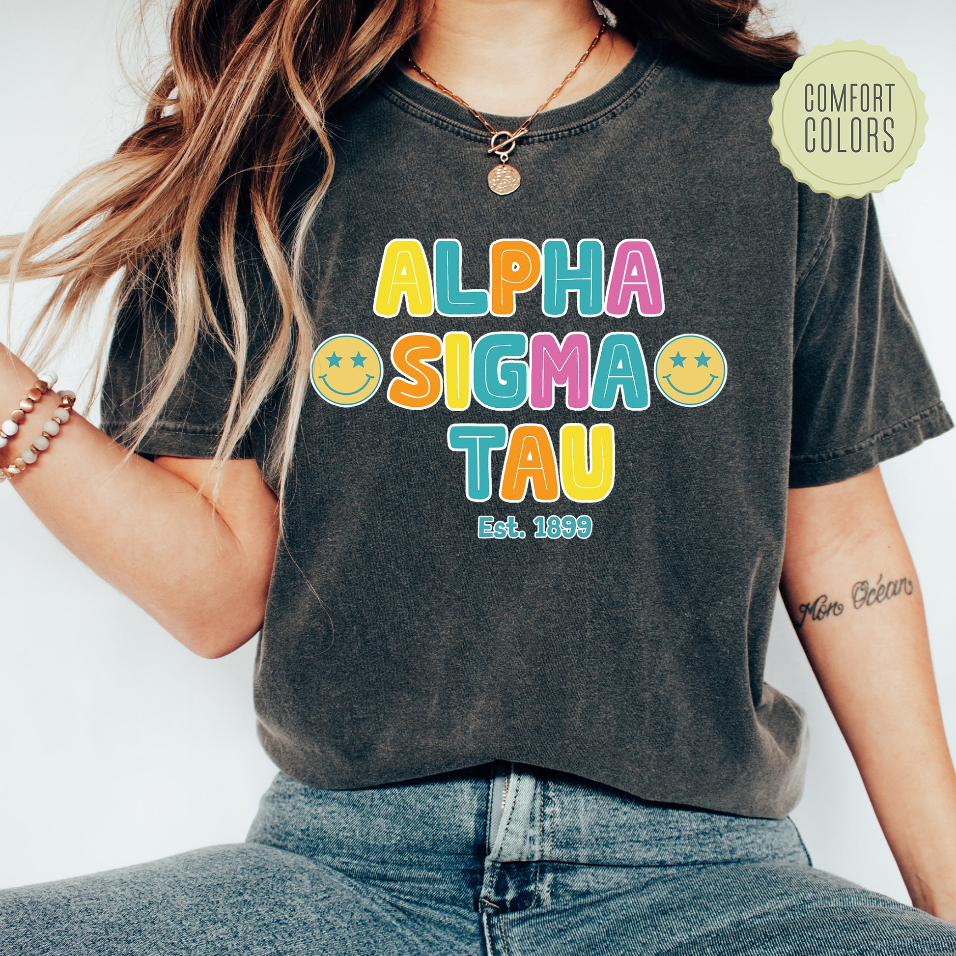 a woman wearing a black shirt with the words alpha sigma tau on