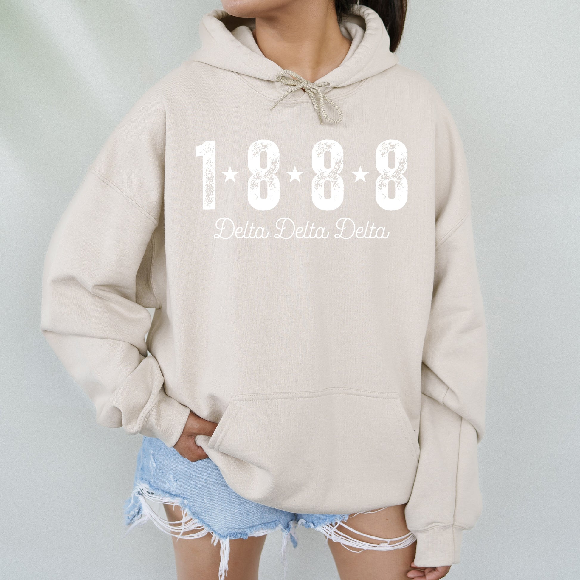 a woman wearing a hoodie with the words delta delta written on it