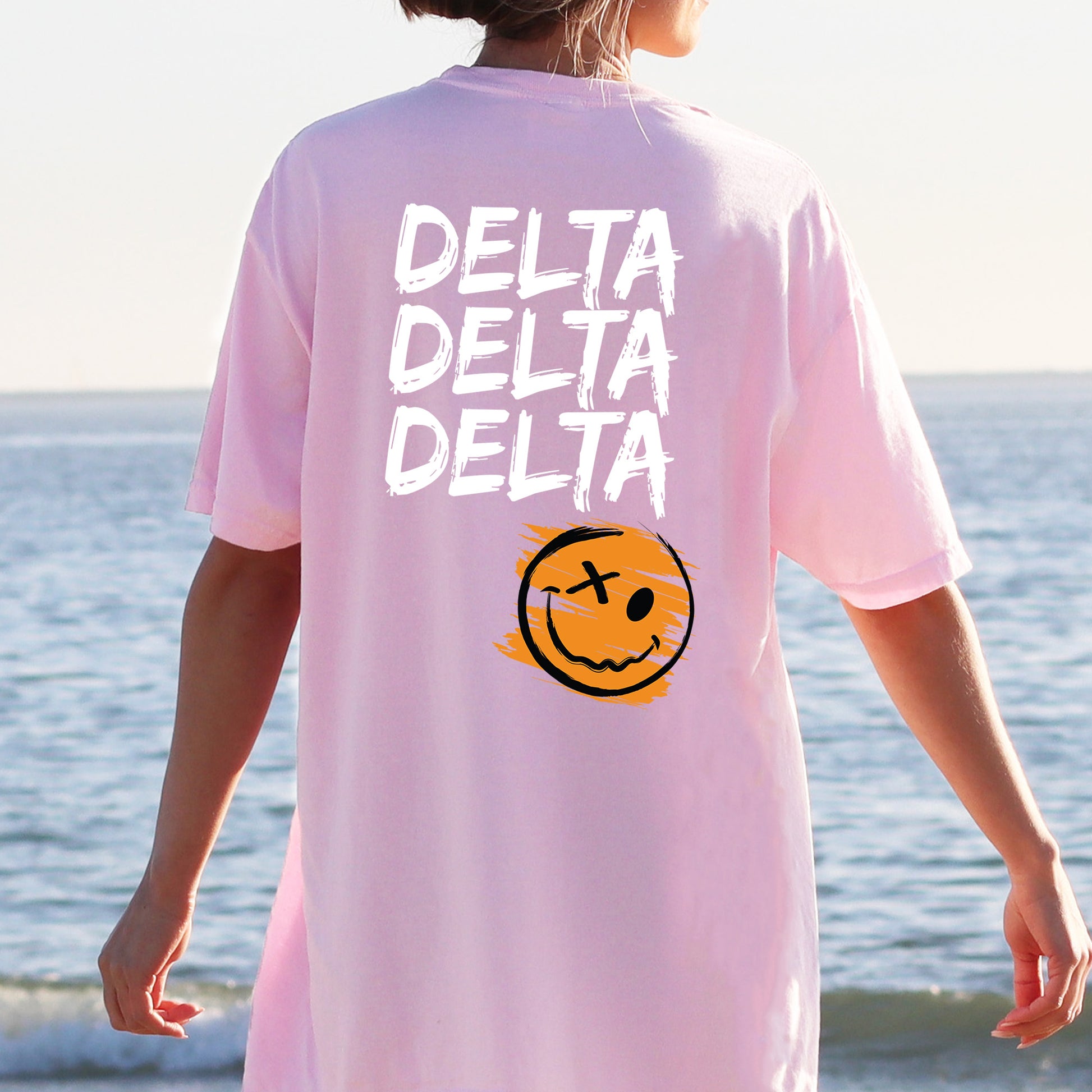a person wearing a pink shirt with a smiley face on it