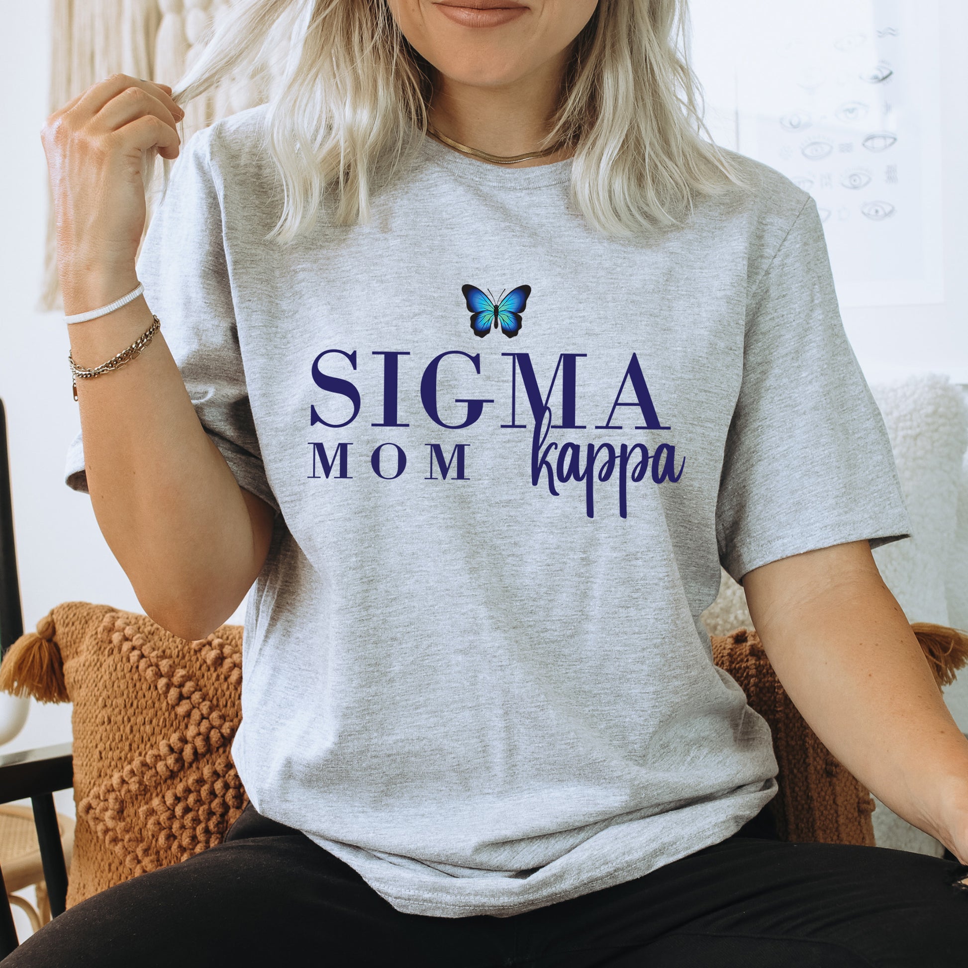a woman sitting in a chair with a butterfly on her shirt