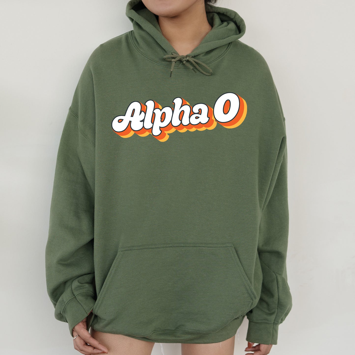 a person wearing a green hoodie with the word alpha on it
