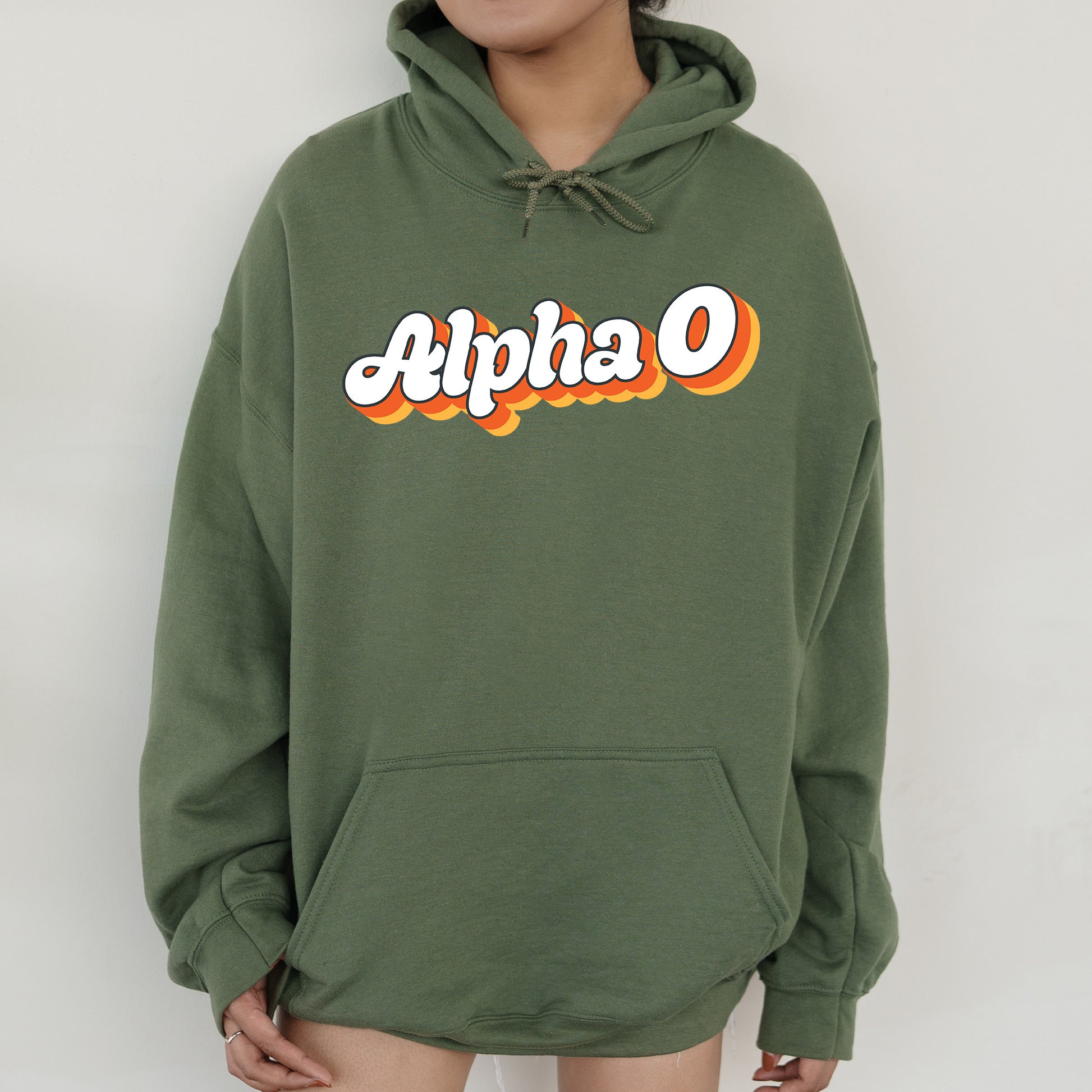 a person wearing a green hoodie with the word alpha on it