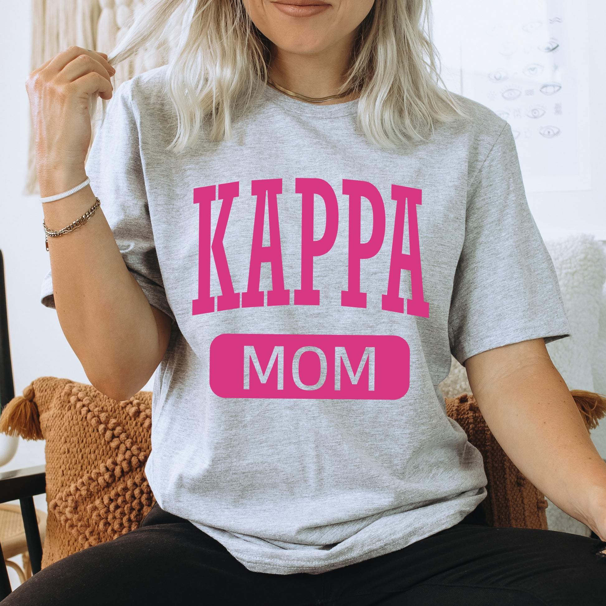 a woman sitting on a chair wearing a t - shirt that says kappa