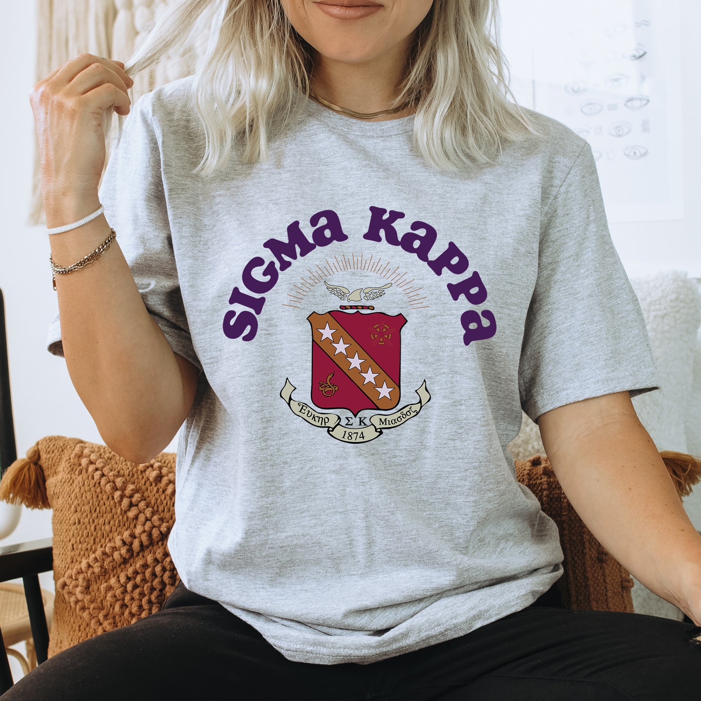 a woman sitting on a chair wearing a gray shirt