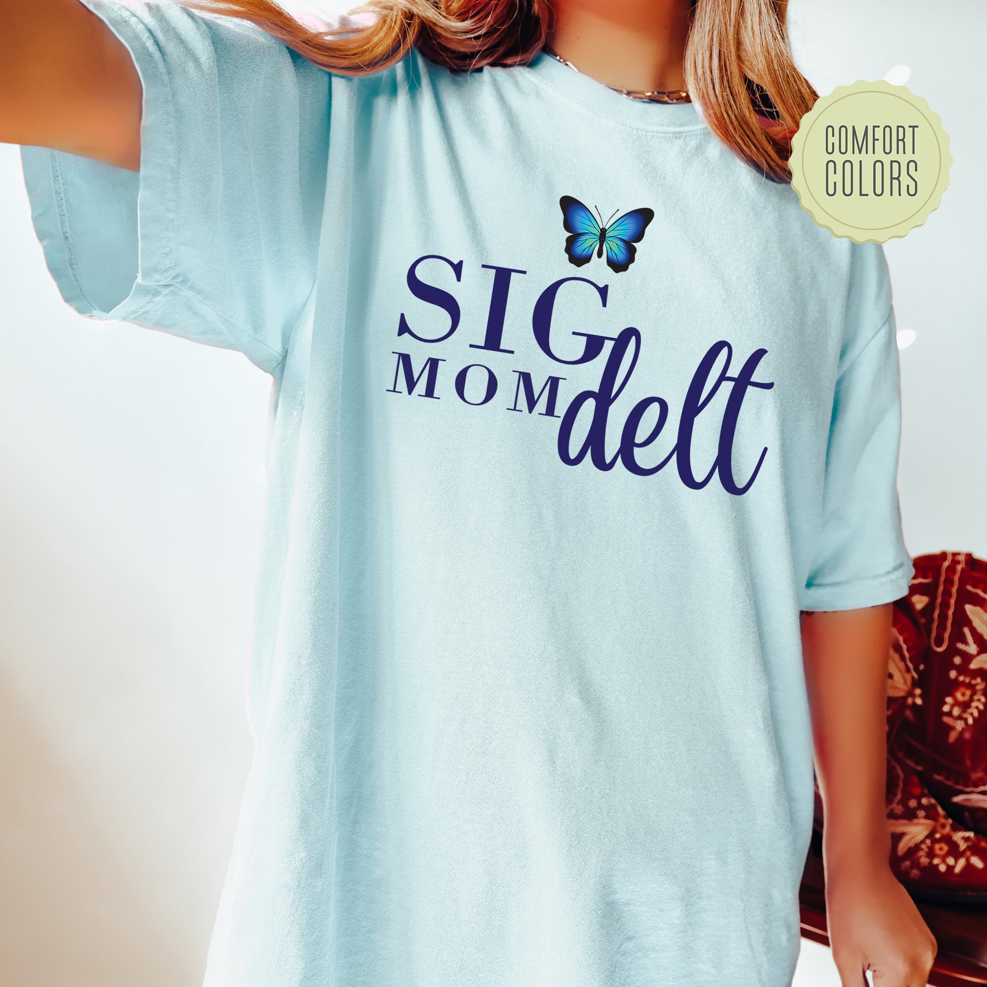 a woman wearing a blue shirt with a butterfly on it