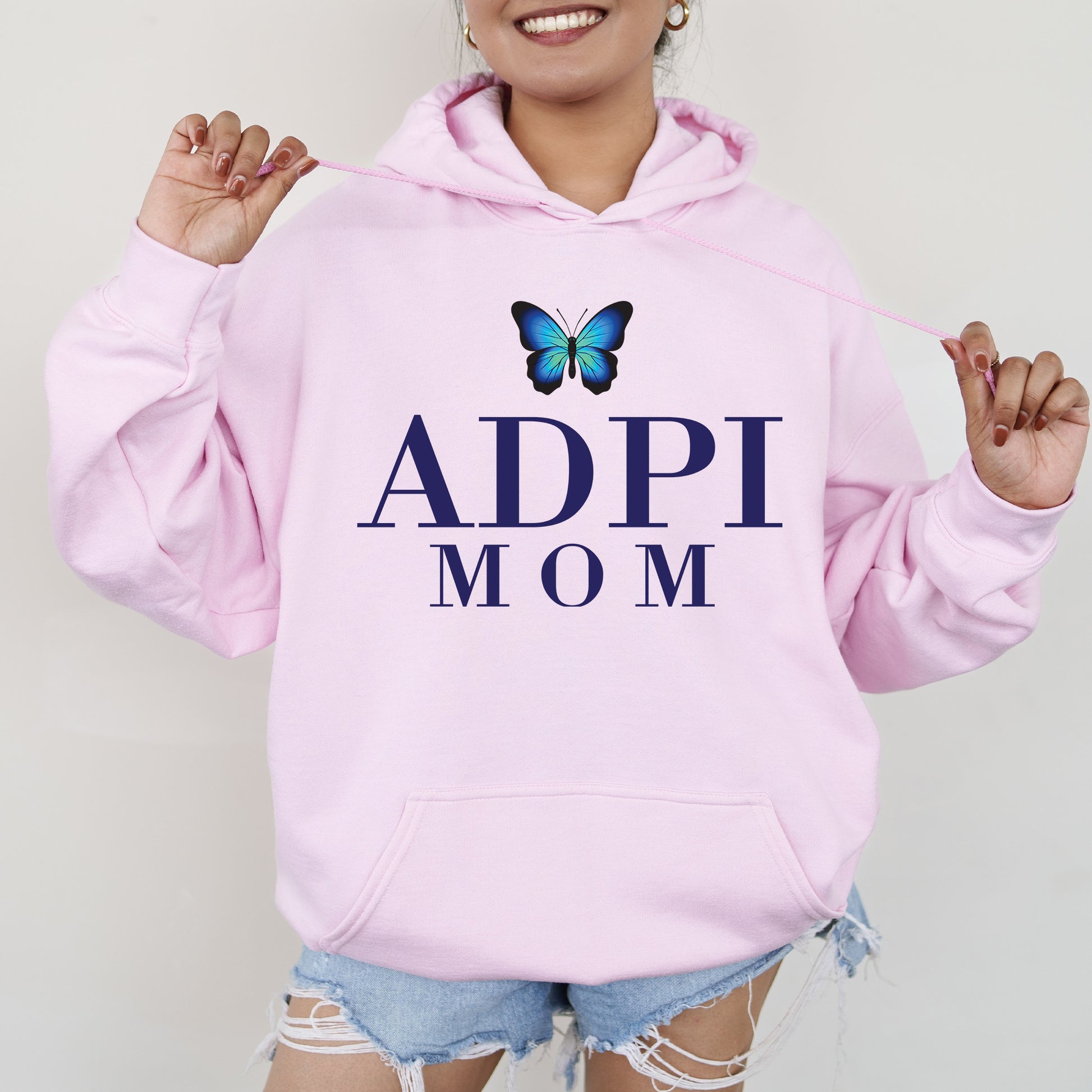 a woman wearing a pink hoodie with a butterfly on it