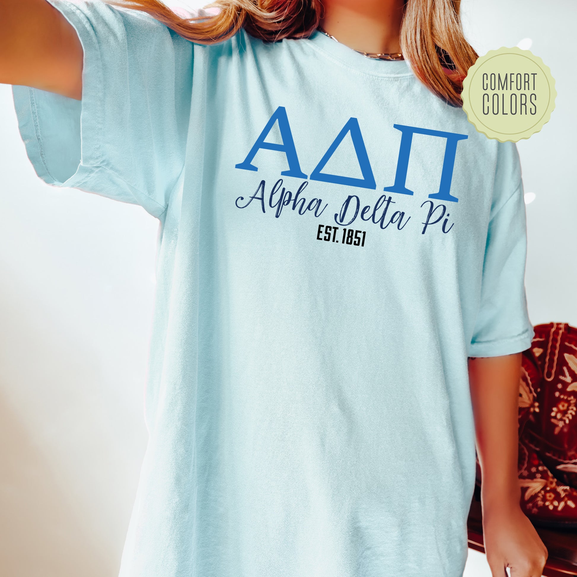 a woman wearing a light blue shirt with the letters aatt on it
