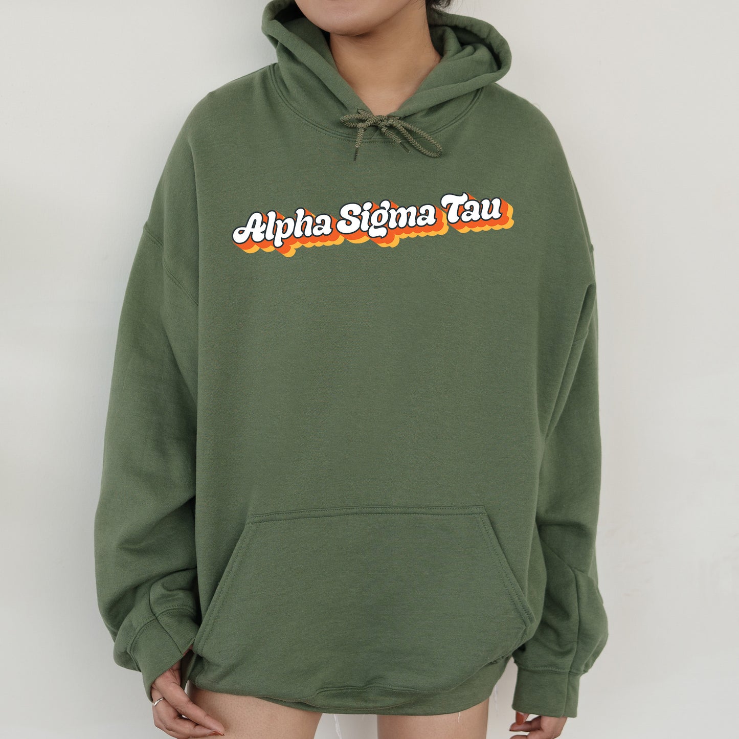 a person wearing a green hoodie with the words alpha stigmata on it