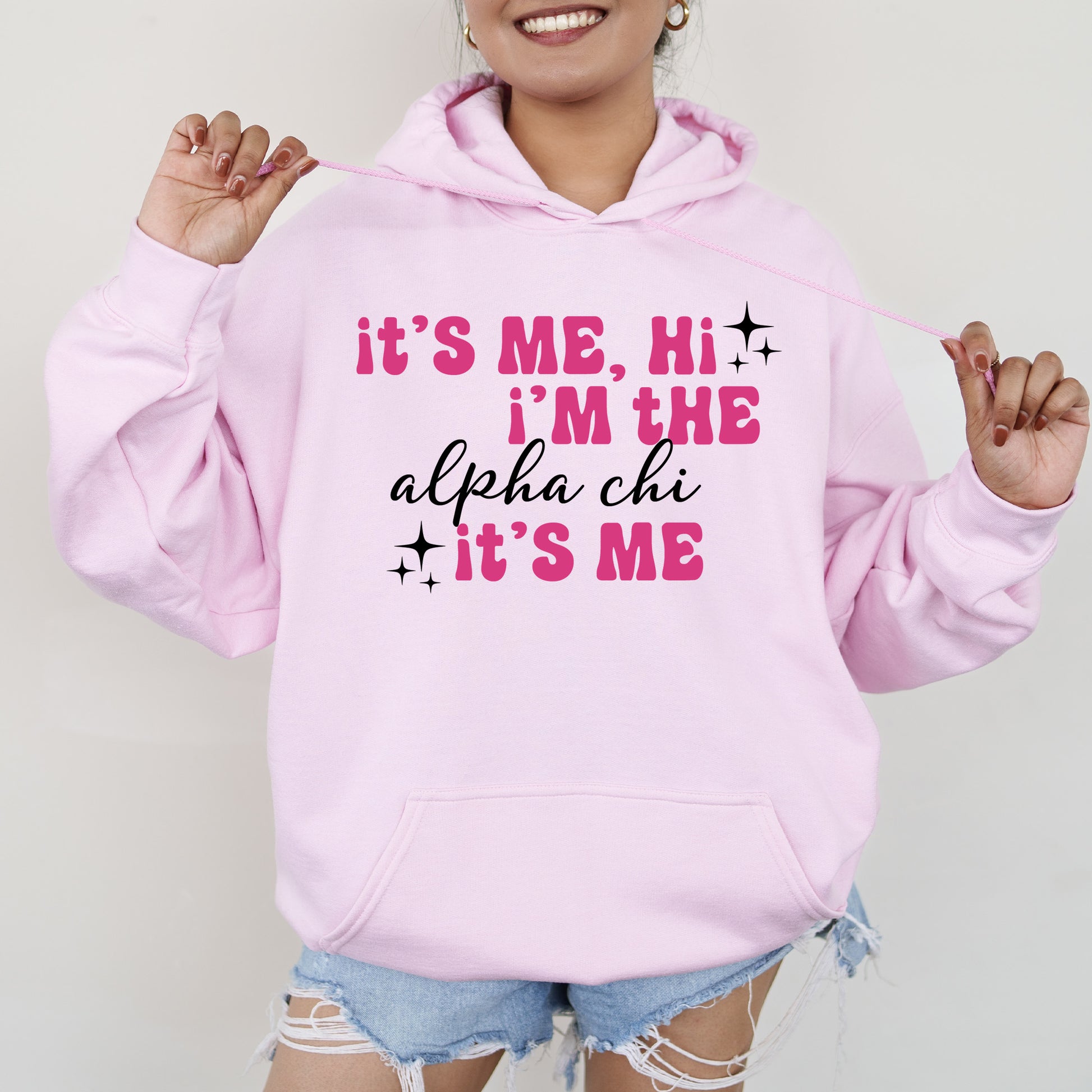 a woman wearing a pink hoodie that says it's me, i '