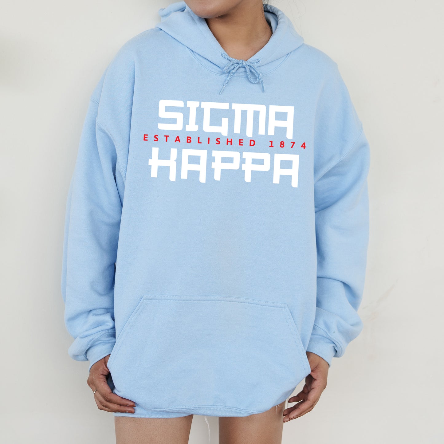 a person wearing a blue hoodie with the words sicta established in white