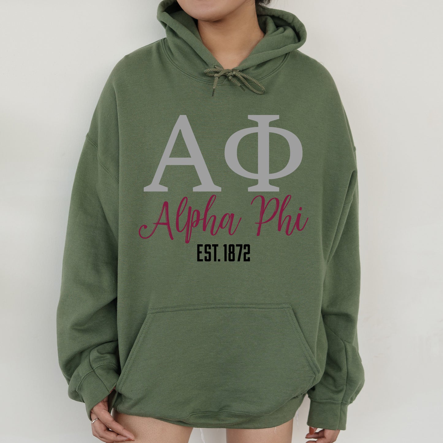 a woman wearing a green phi phi hoodie