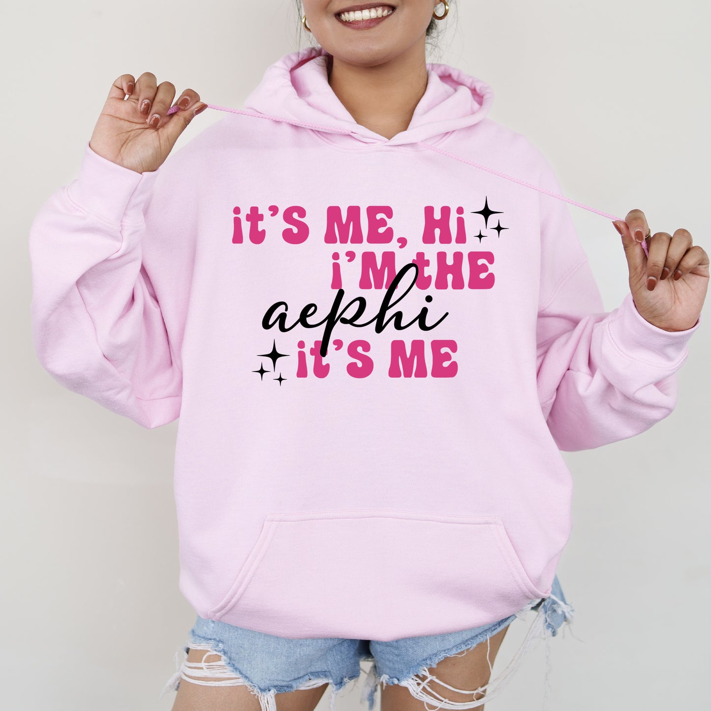 a woman wearing a pink hoodie that says it's me, he '
