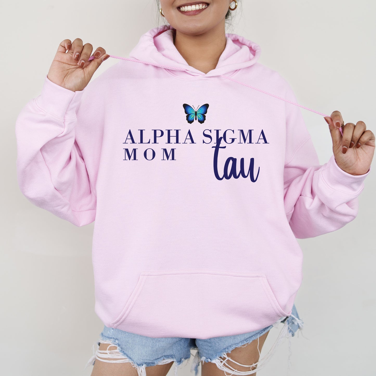 a woman wearing a pink hoodie with a butterfly on it