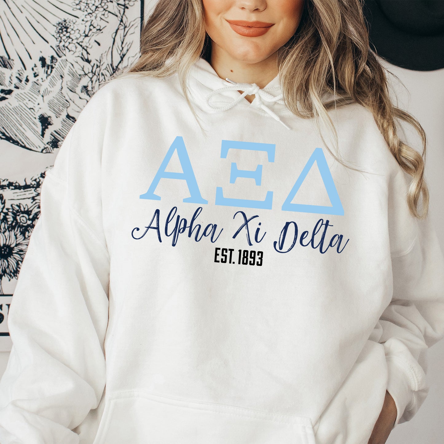 a woman wearing a white hoodie with blue letters on it