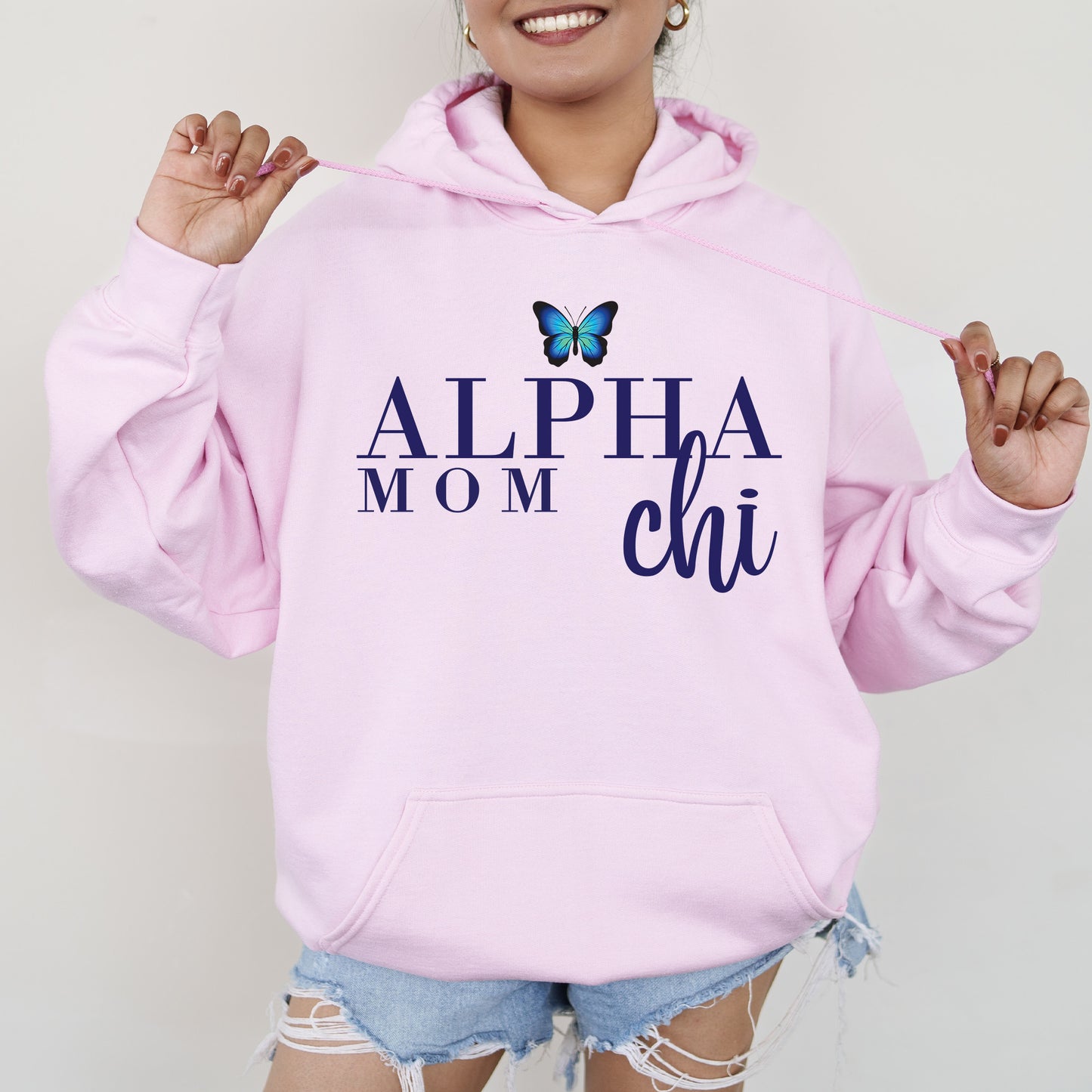 a woman wearing a pink hoodie with a butterfly on it