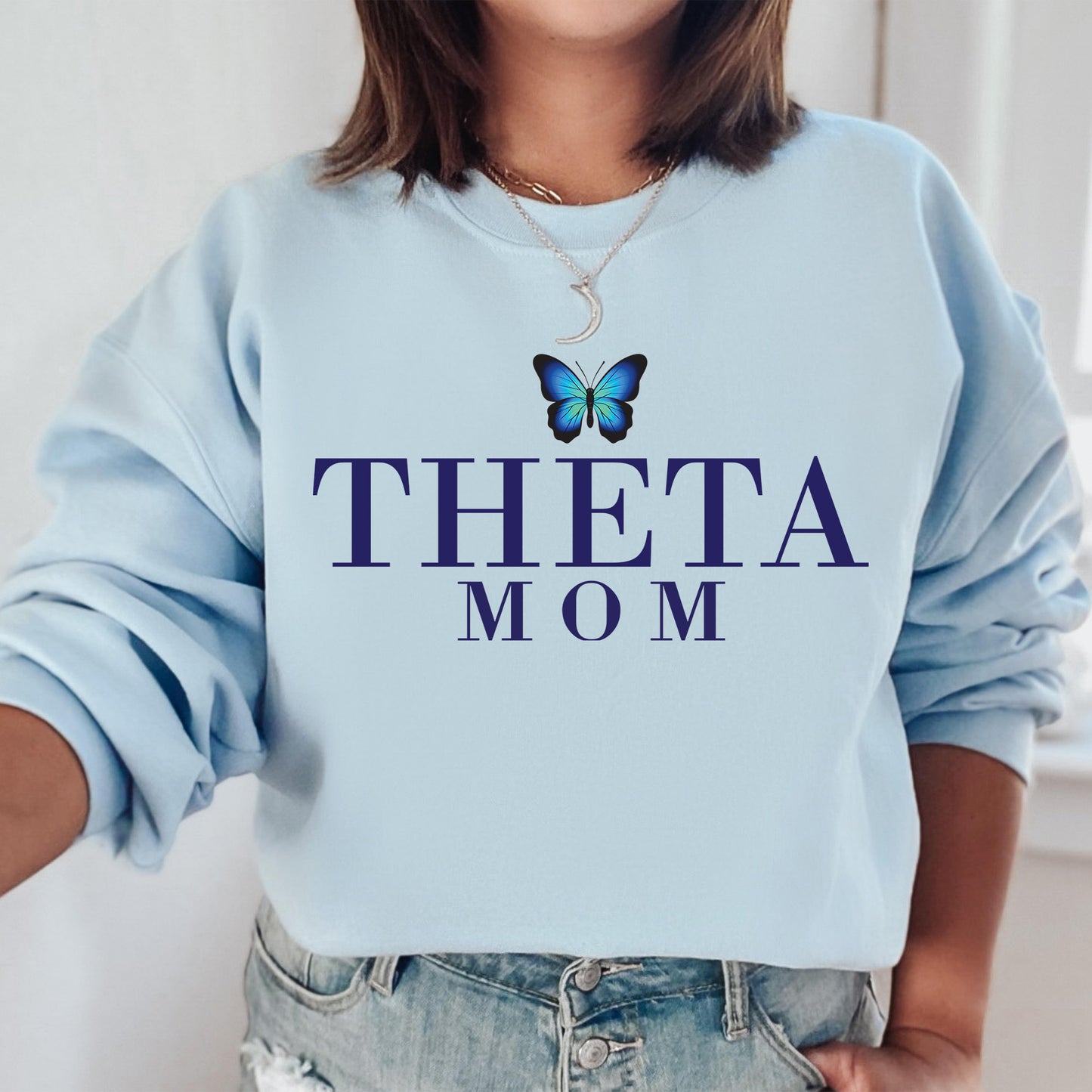 a woman wearing a blue sweatshirt with a butterfly on it