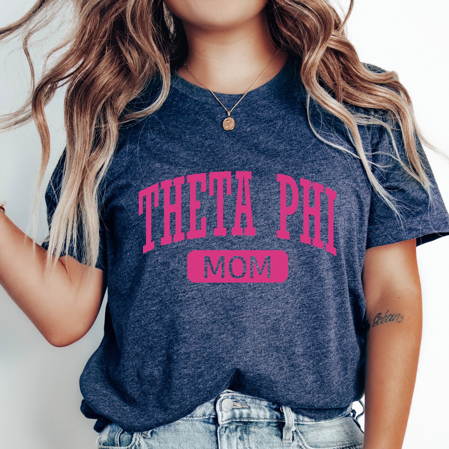 a woman wearing a t - shirt that says thea phi mom