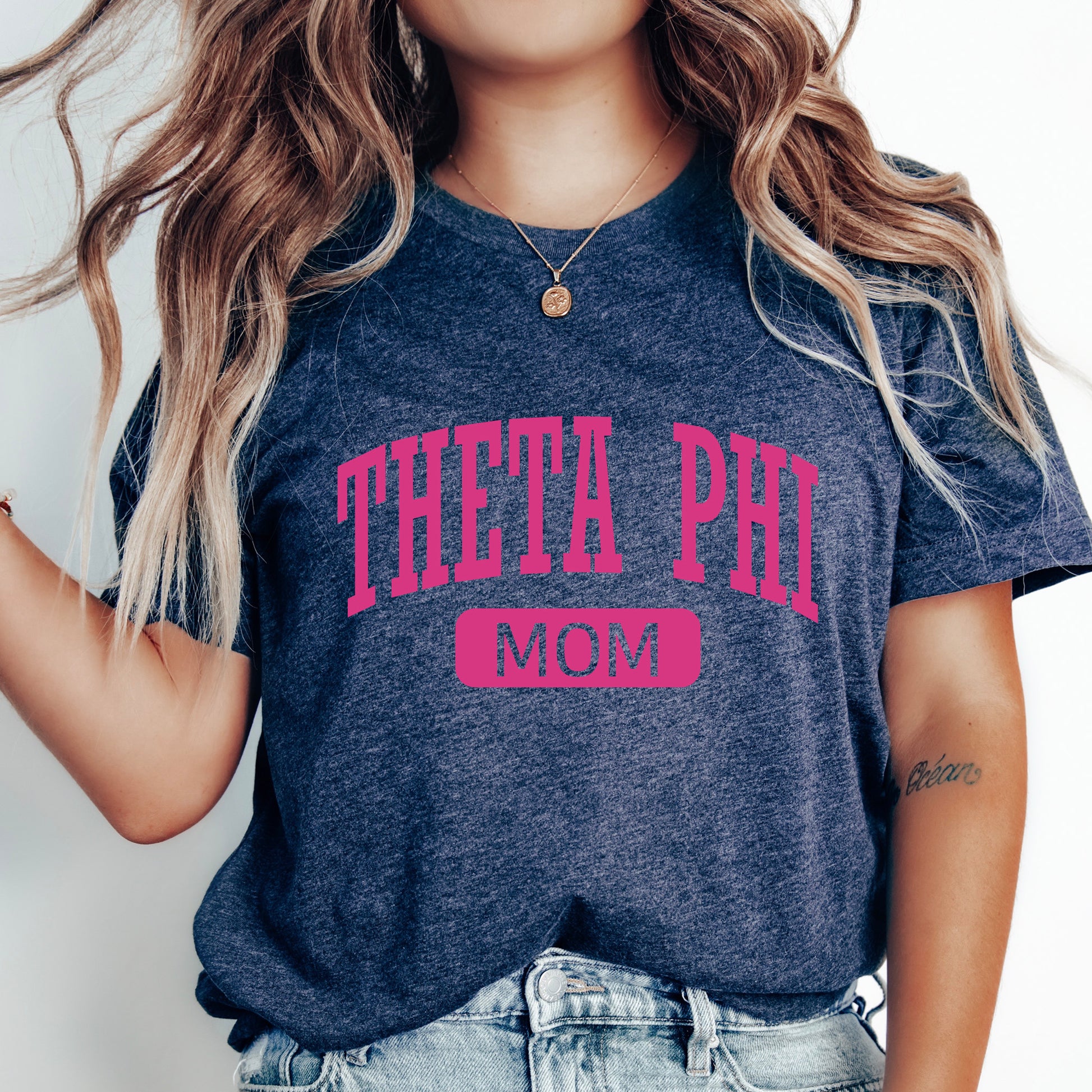 a woman wearing a t - shirt that says thea phi mom