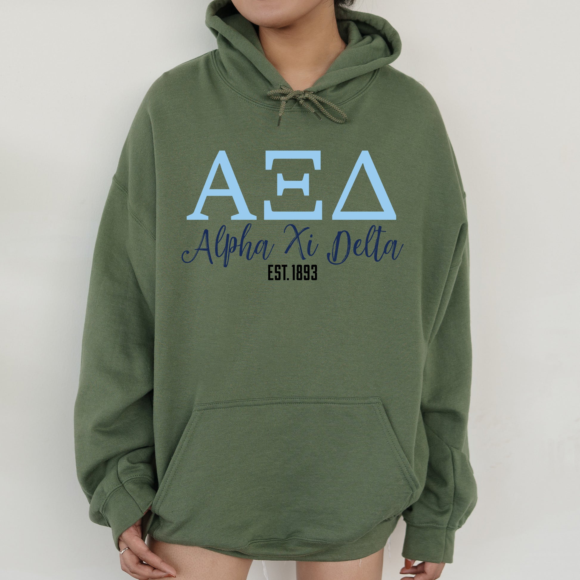 a person wearing a green hoodie with the aea logo on it
