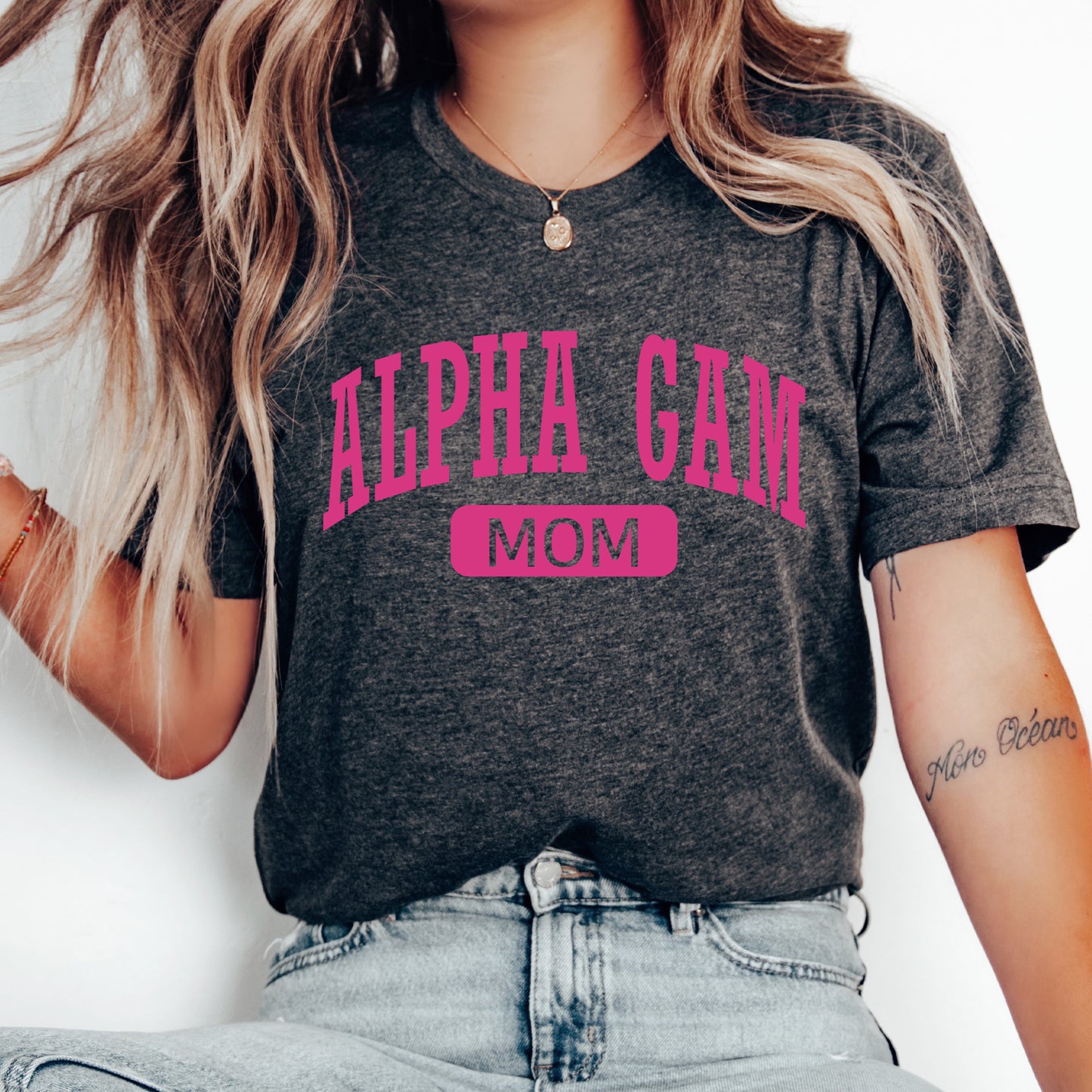 a woman wearing a gray shirt with pink letters on it