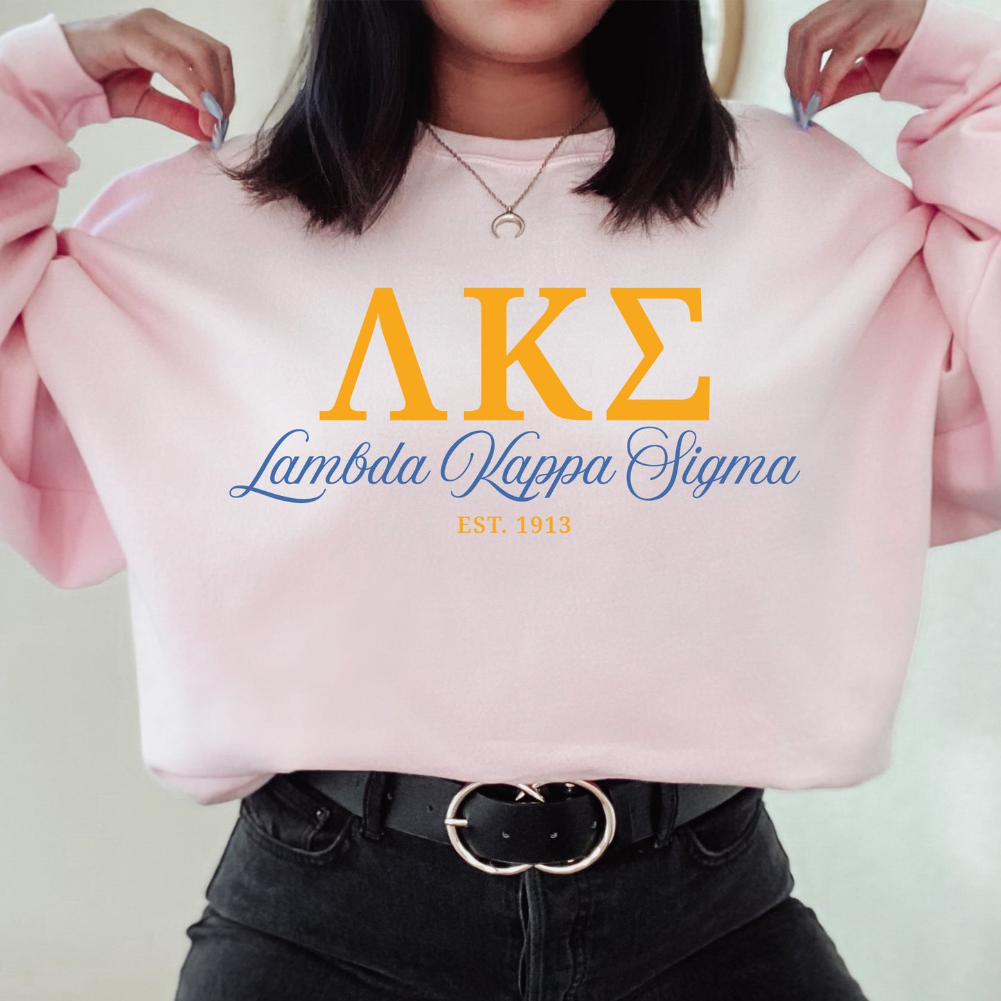 a woman is holding a pink sweater with the letters ake on it