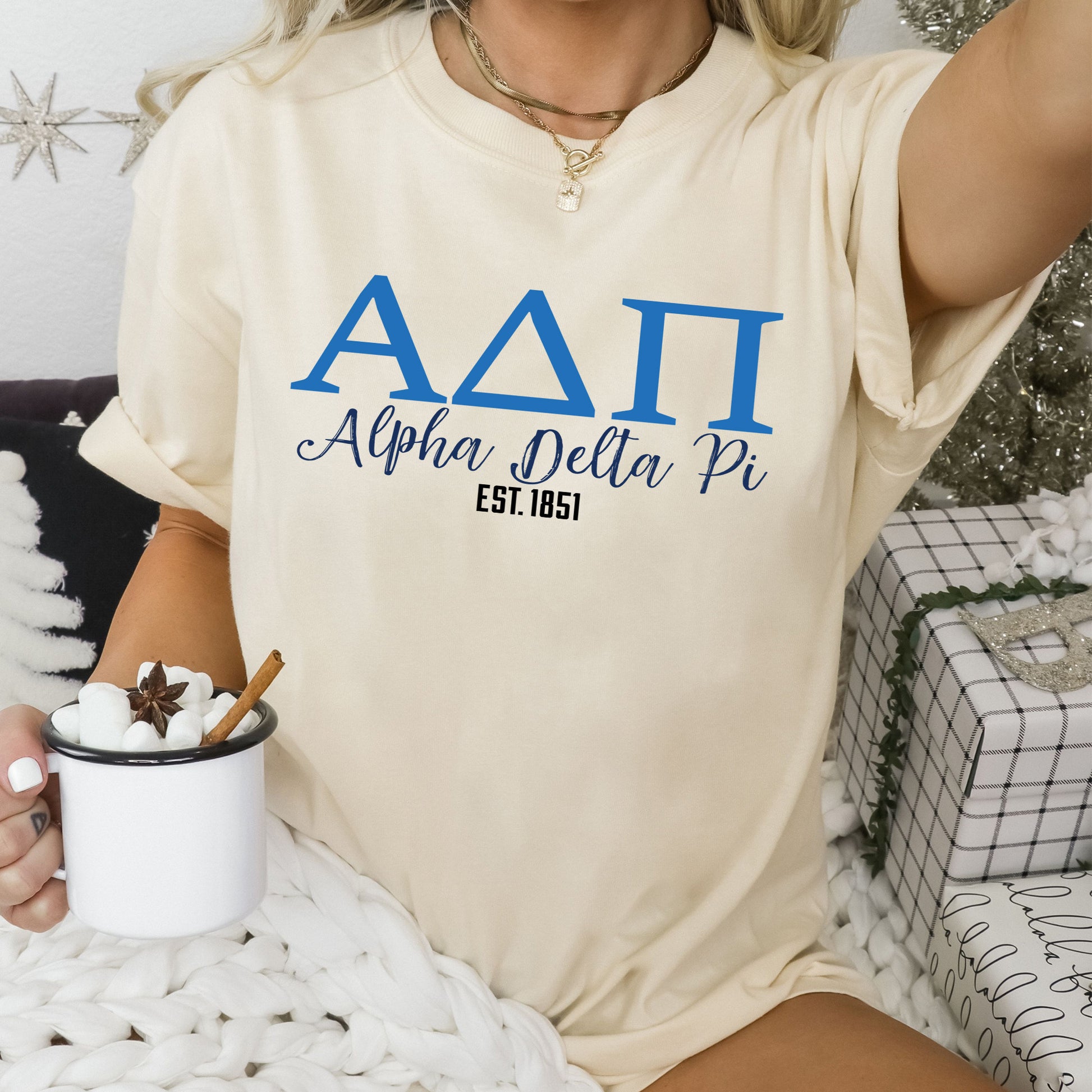 a woman sitting on a bed holding a cup of coffee