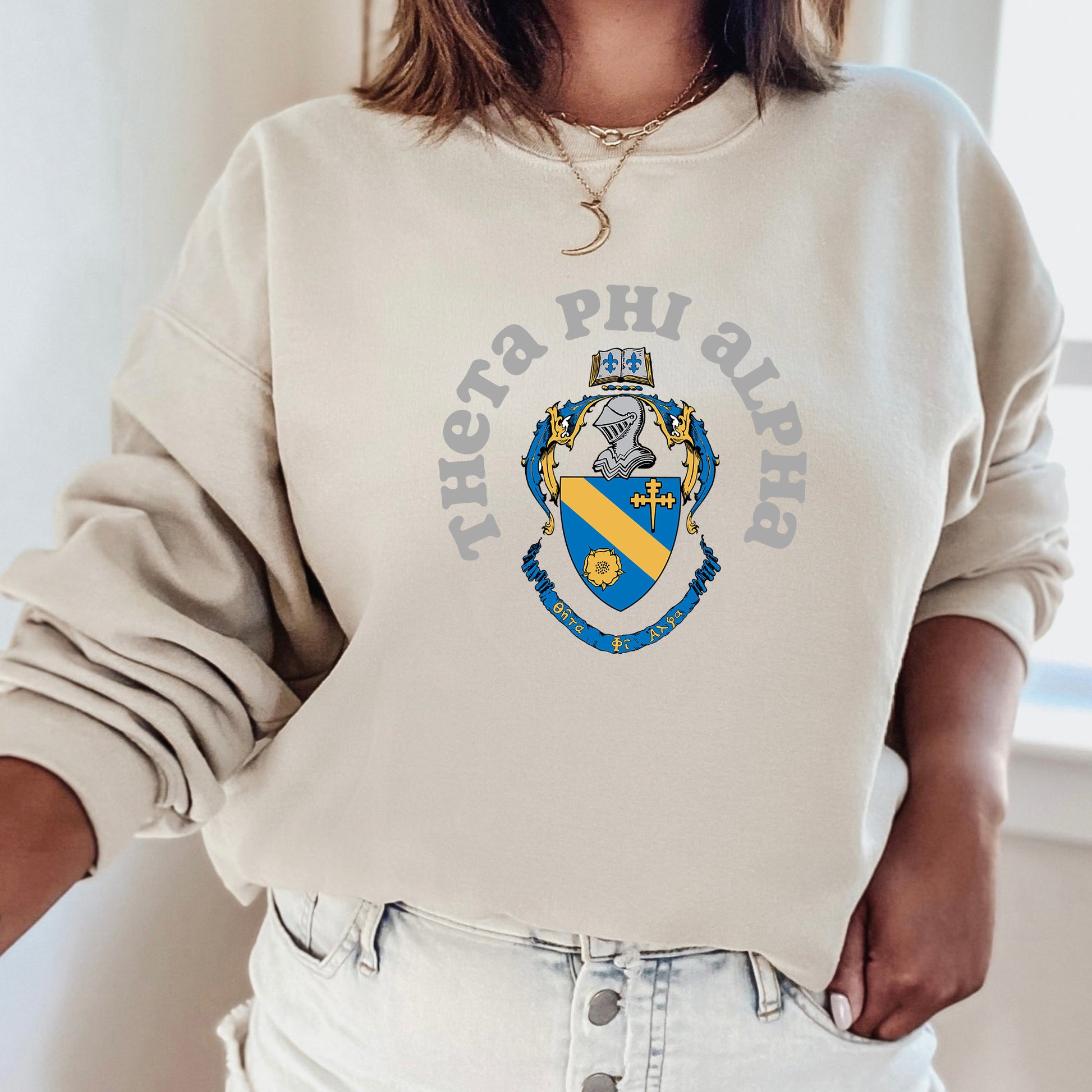 a woman wearing a white sweatshirt with a blue and yellow crest on it