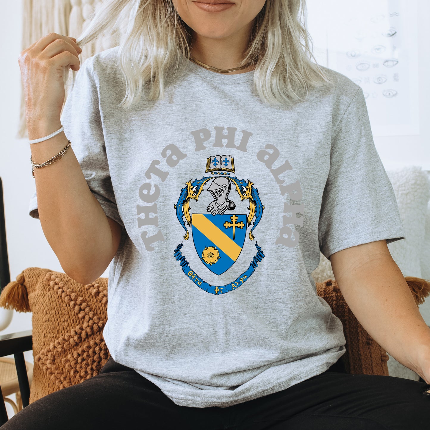 a woman sitting on a chair wearing a t - shirt with a coat of arms