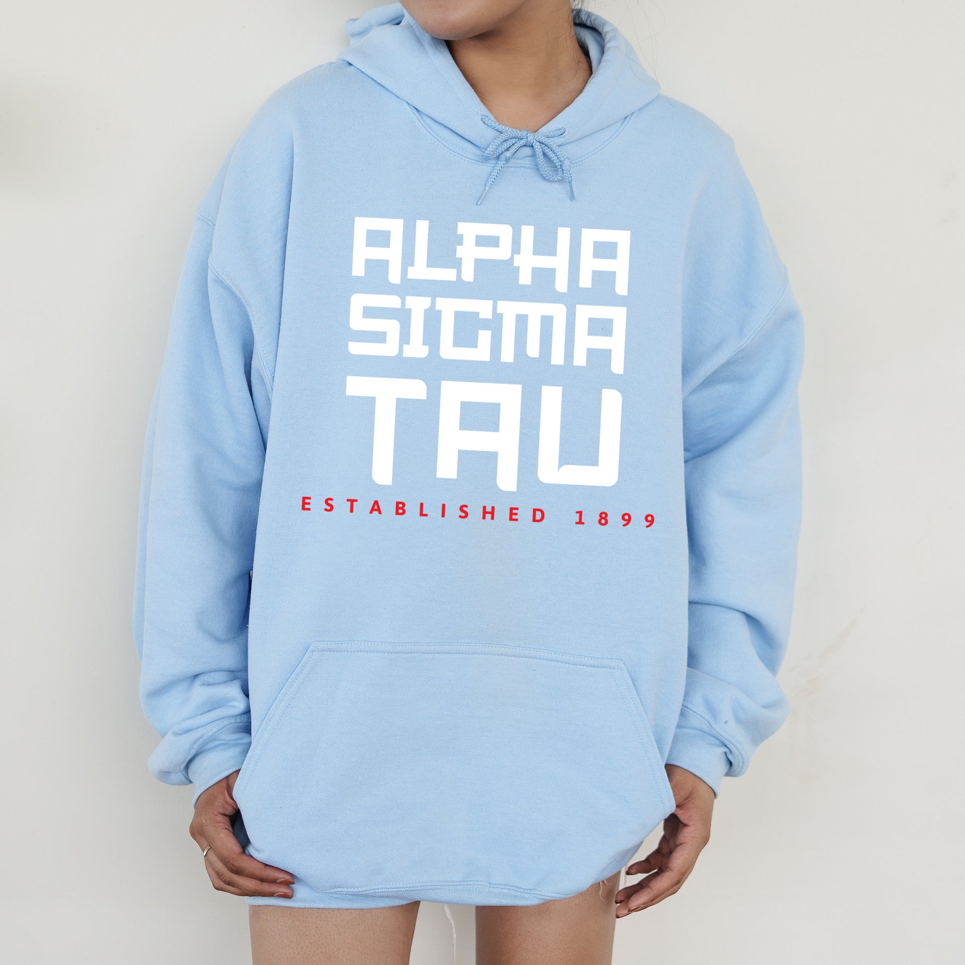 a person wearing a blue hoodie with the words alpha sioma tau