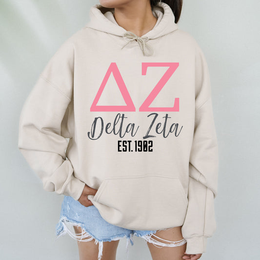 a woman wearing a white hoodie with a pink delta delta on it