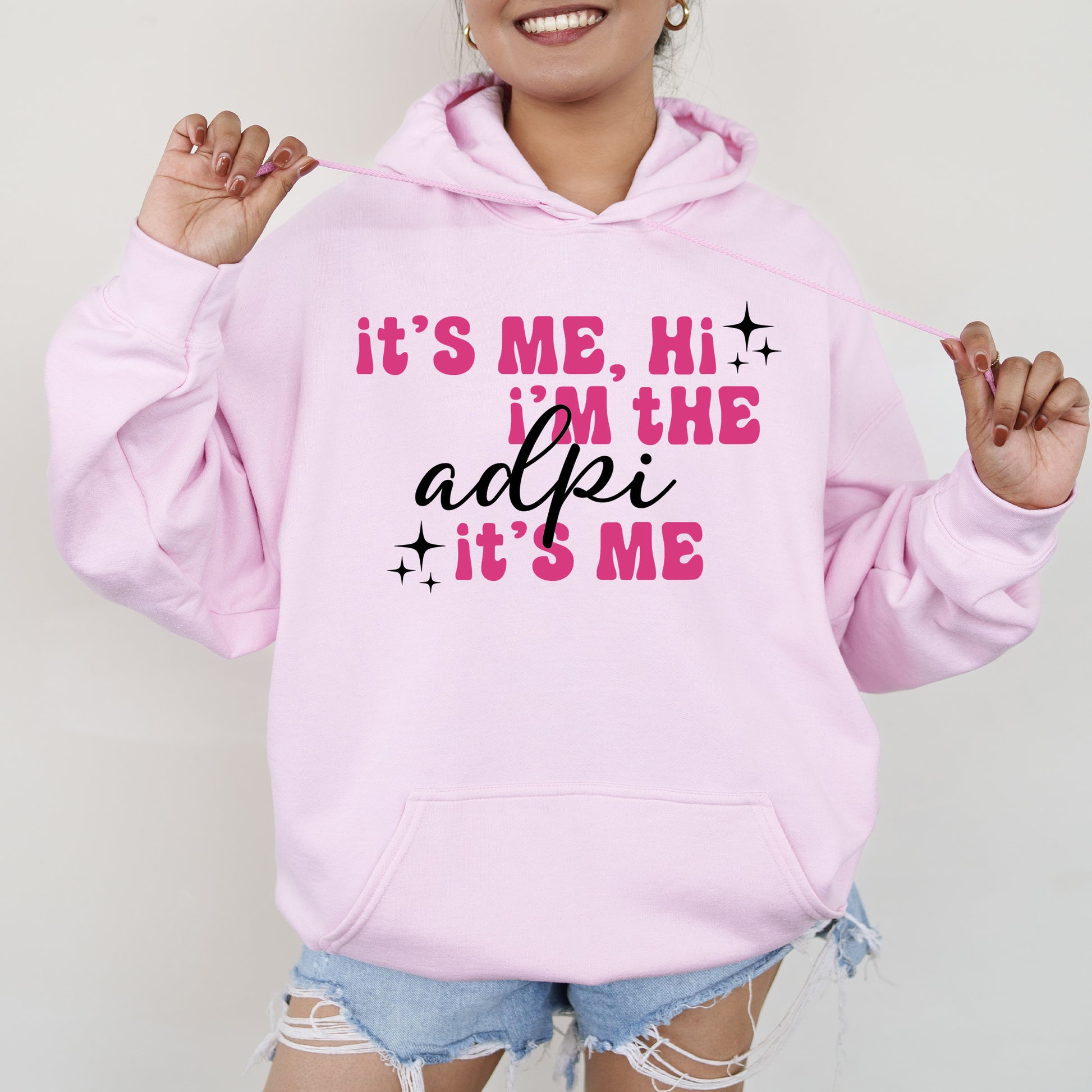 a woman wearing a pink hoodie that says it's me, he '