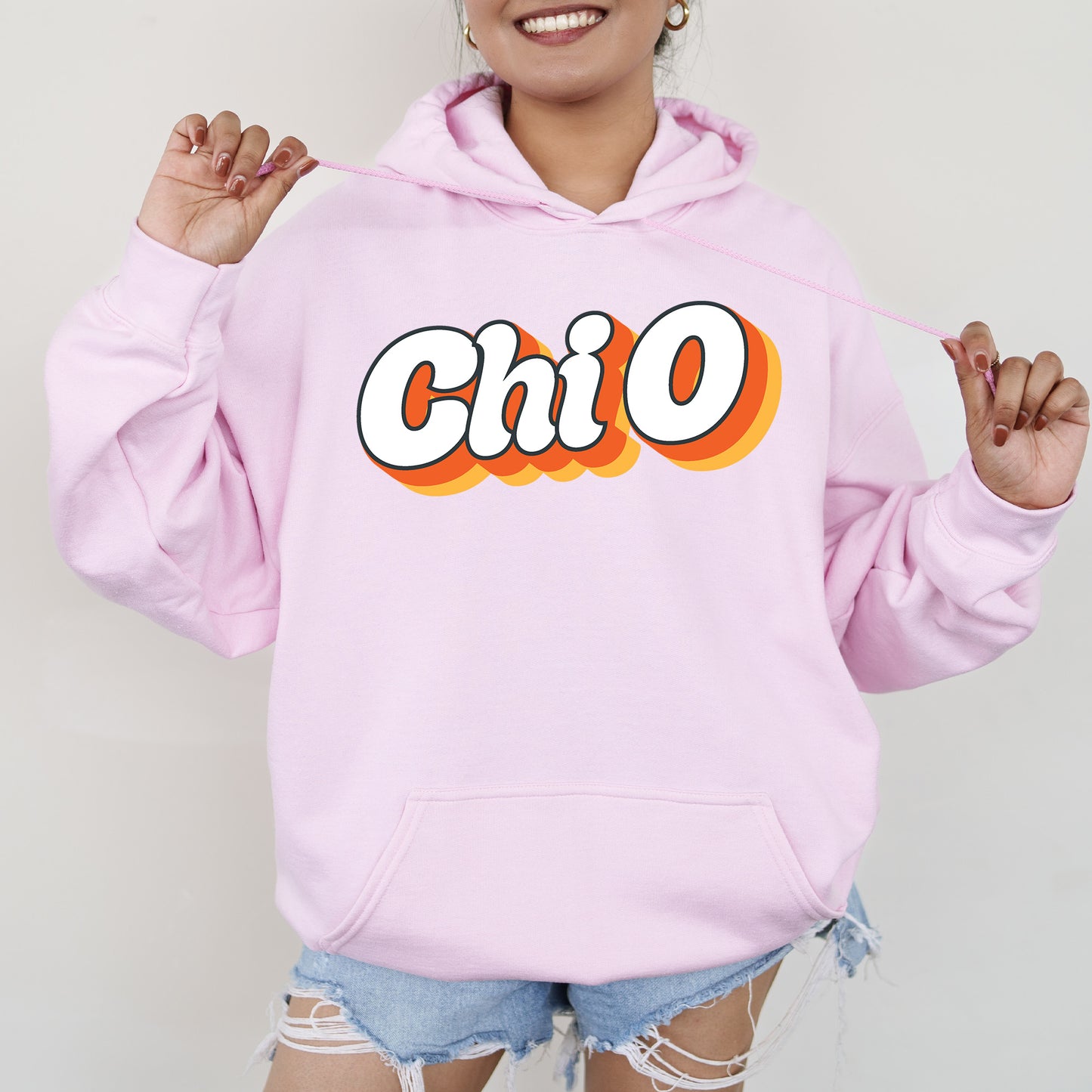 a woman wearing a pink hoodie with the word chio on it