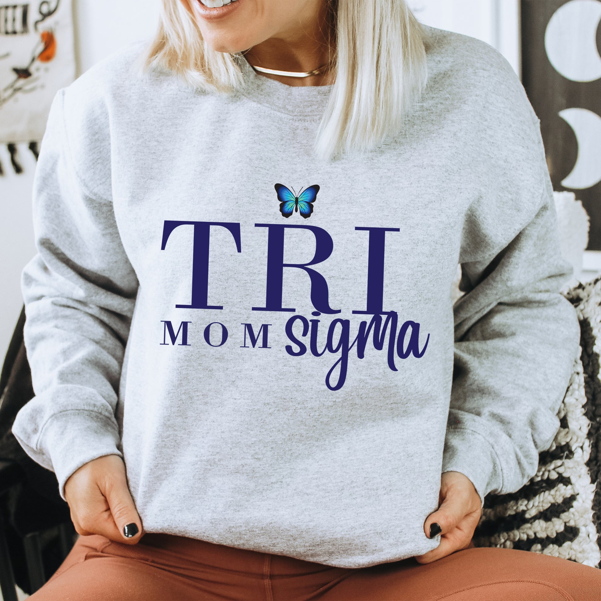 a woman sitting on a chair with a butterfly on her sweatshirt