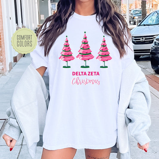 a woman wearing a white shirt with christmas trees on it
