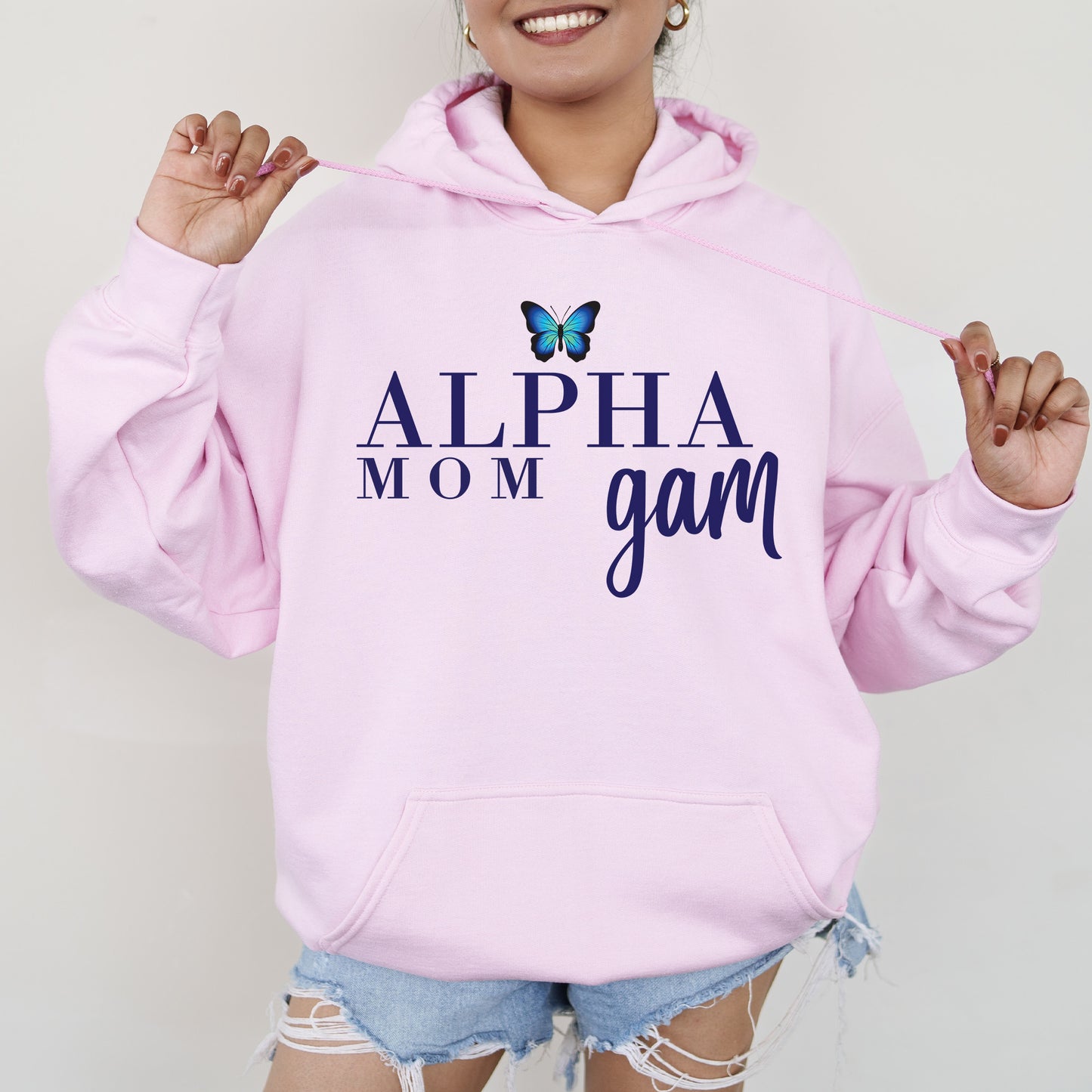 a woman wearing a pink hoodie with a butterfly on it