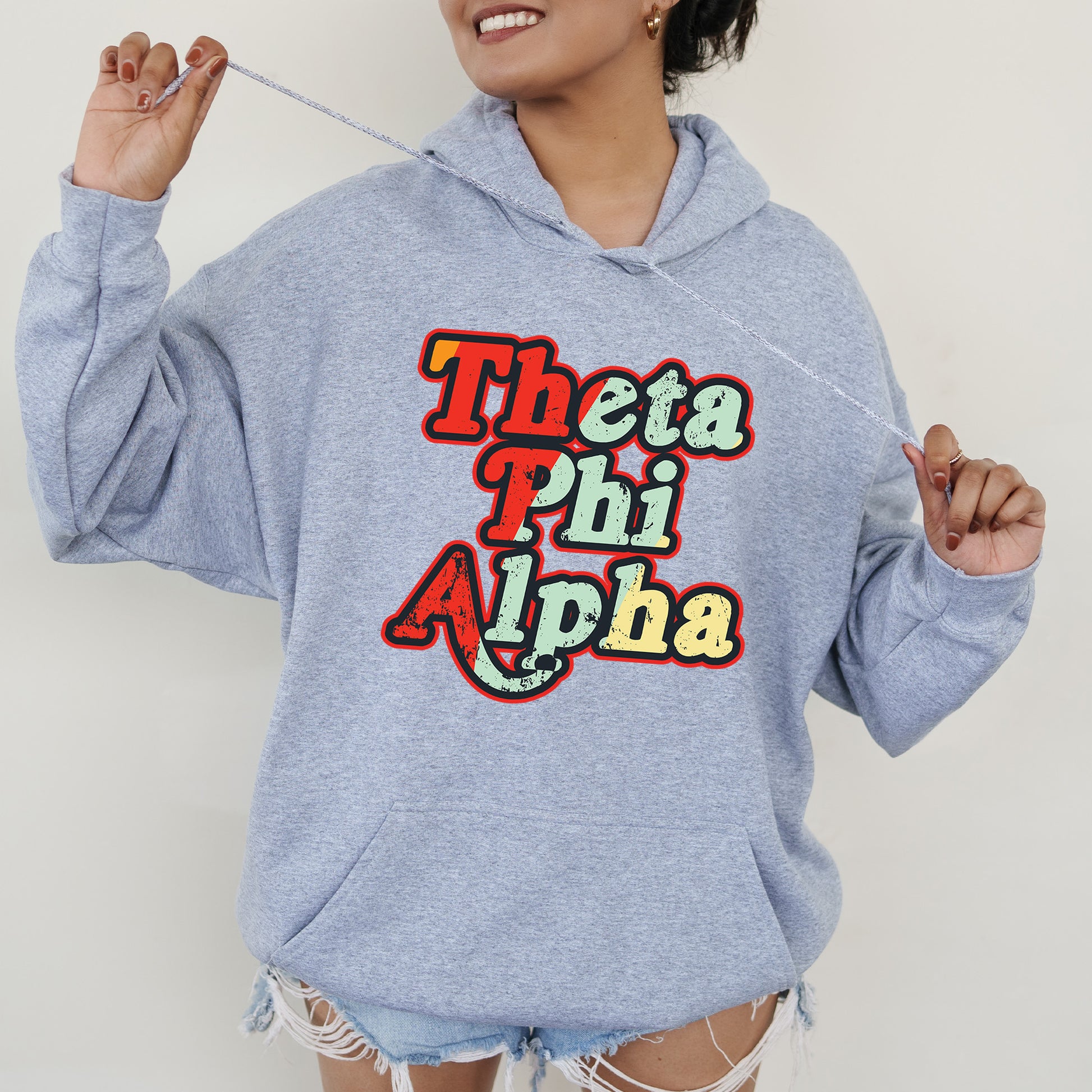 a woman wearing a blue sweatshirt with the words thea phi alpha on it