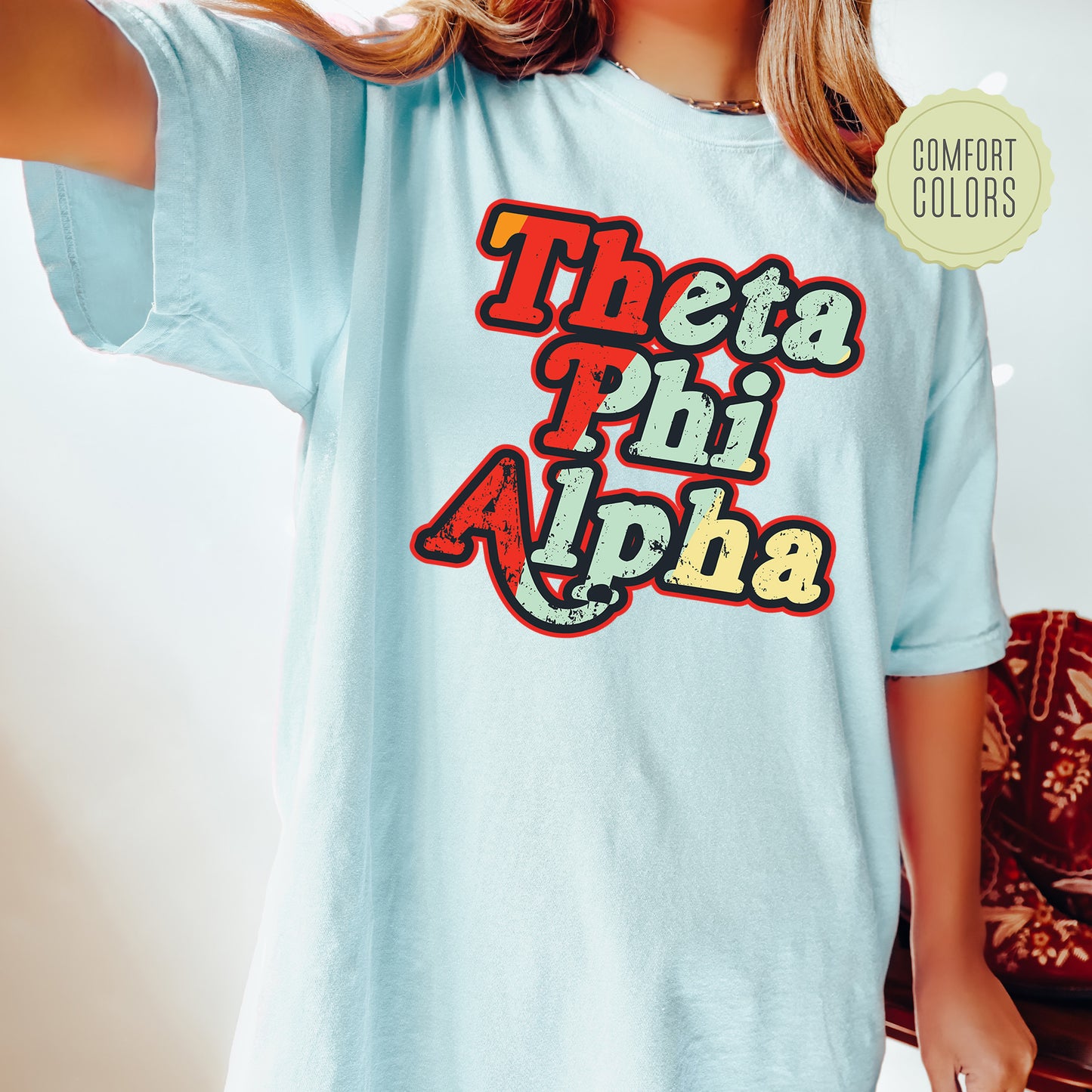 a woman wearing a blue shirt with the words thea phi aha on it