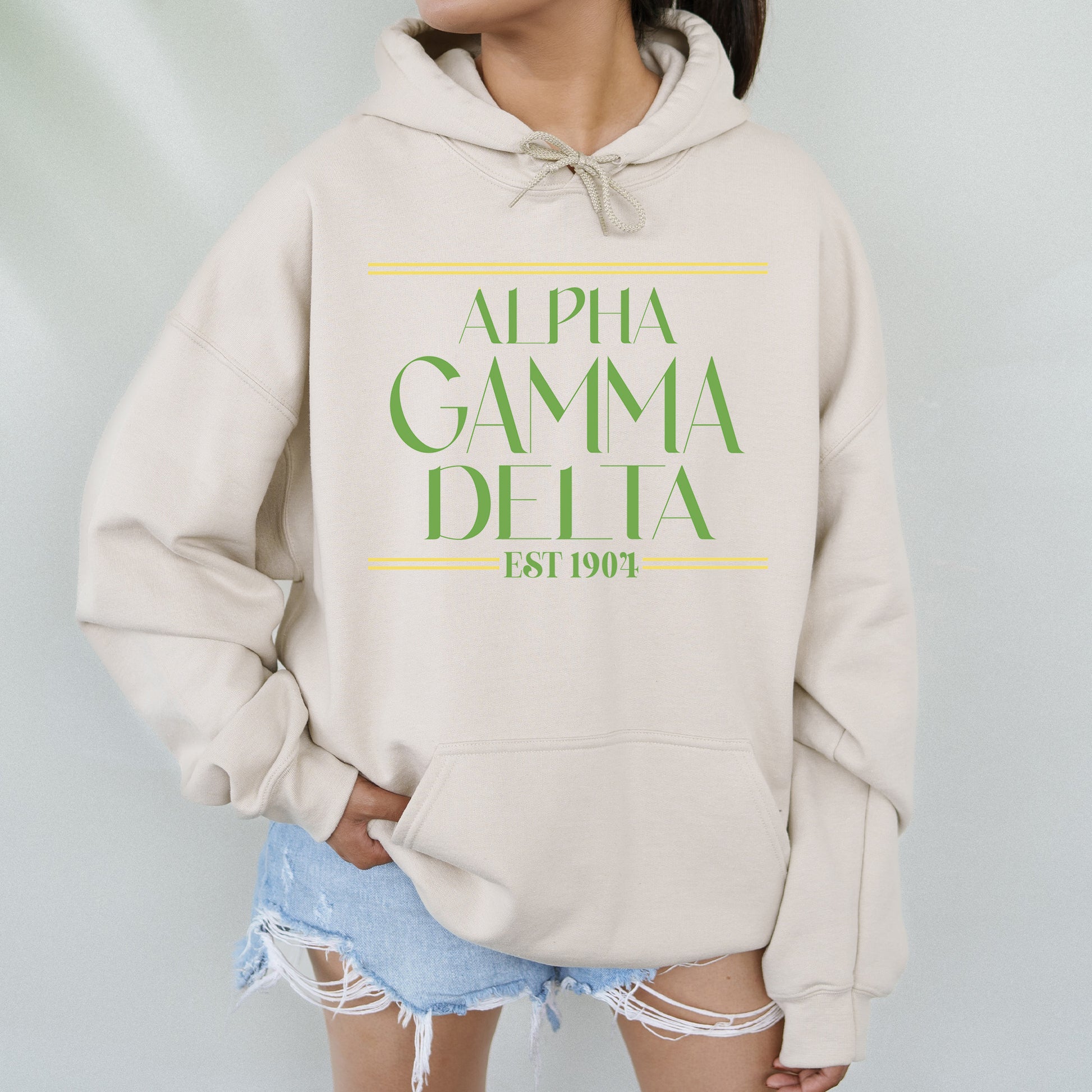 a woman wearing a white sweatshirt with the words, alpha gama delta on it