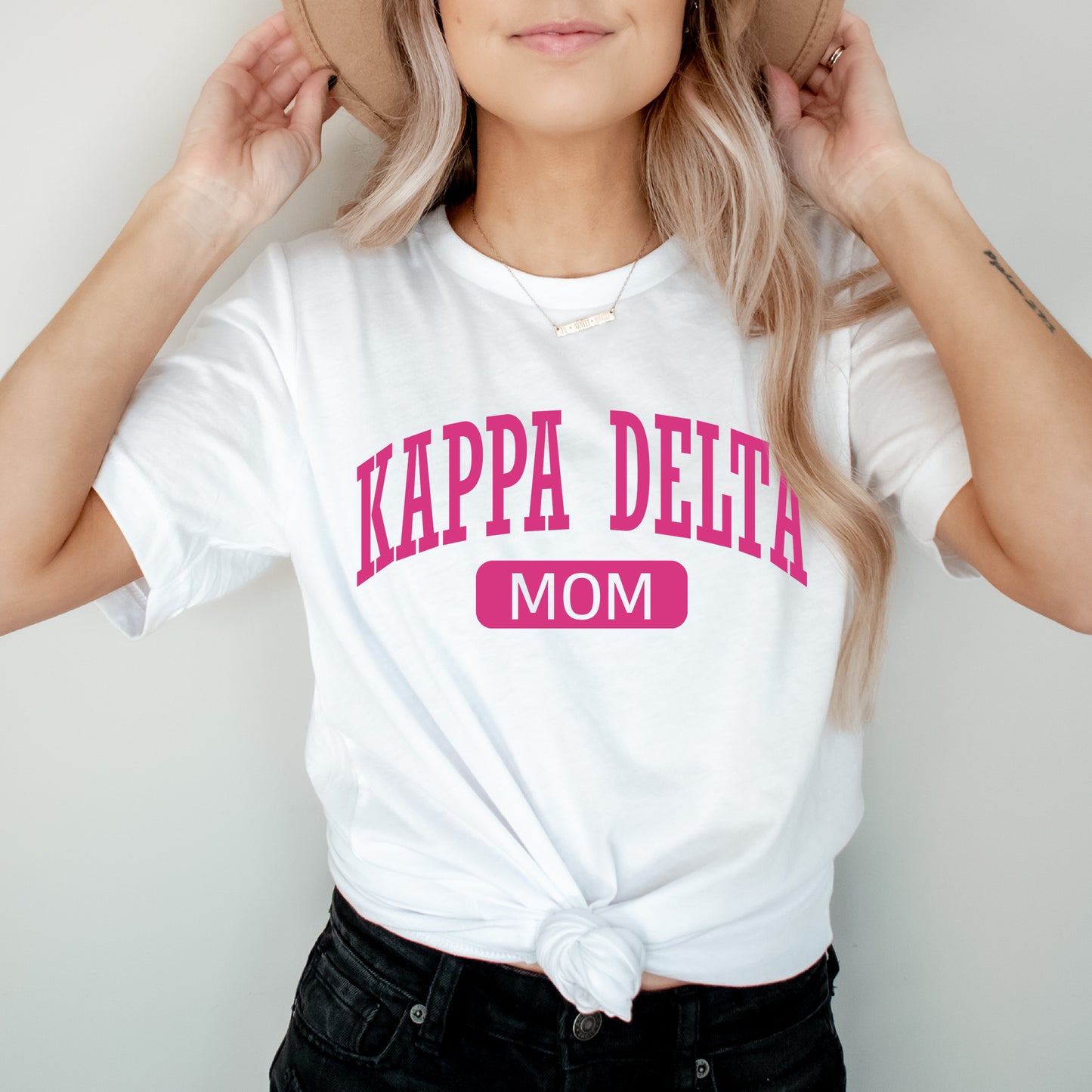 a woman wearing a hat and a t - shirt that says kappa delta