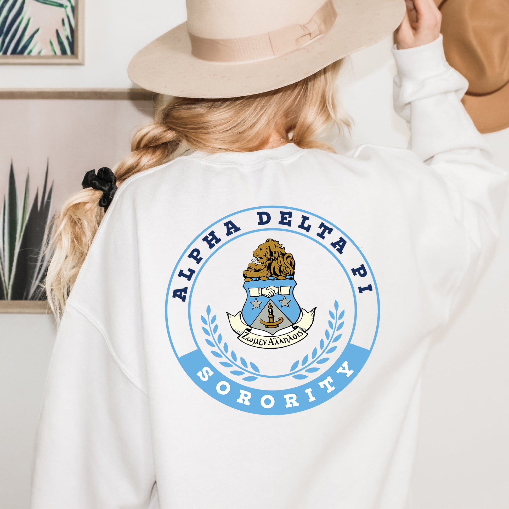 a woman wearing a white sweatshirt and a hat
