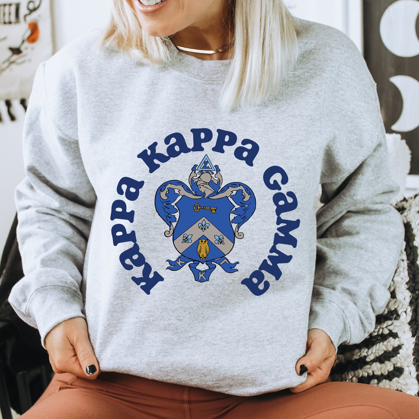 a woman sitting on a chair wearing a gray sweatshirt