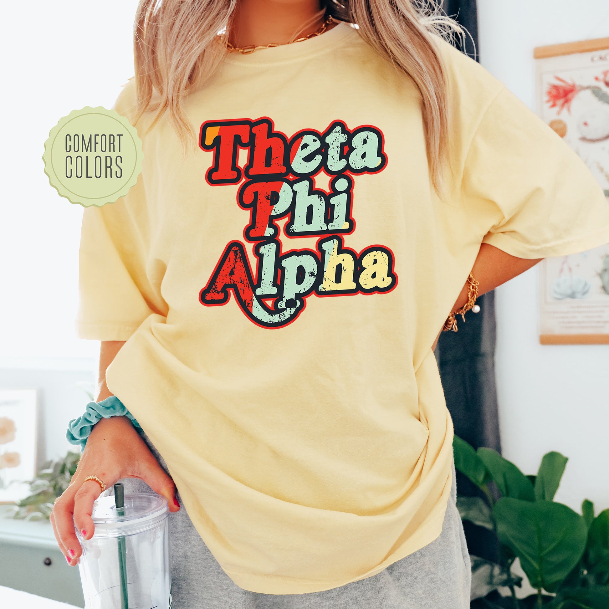 a woman wearing a yellow t - shirt that says, thea phi alpha
