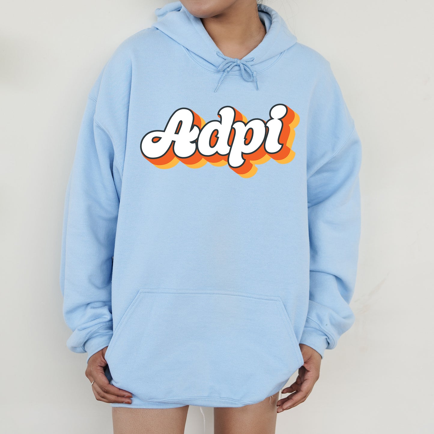a person wearing a blue hoodie with the word adpi printed on it