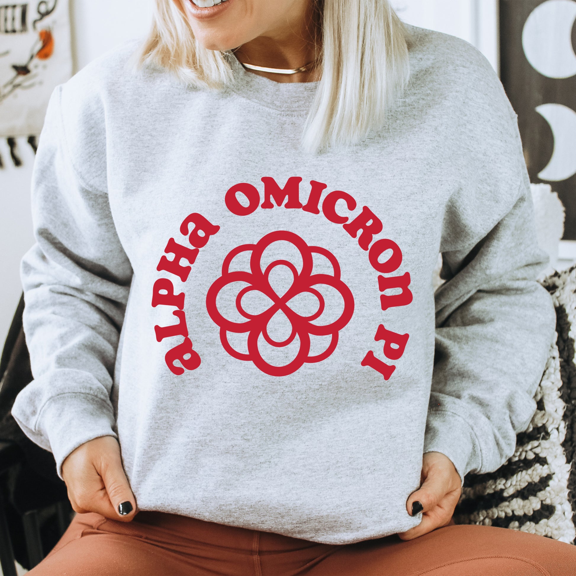 a woman sitting on a chair wearing a grey sweatshirt