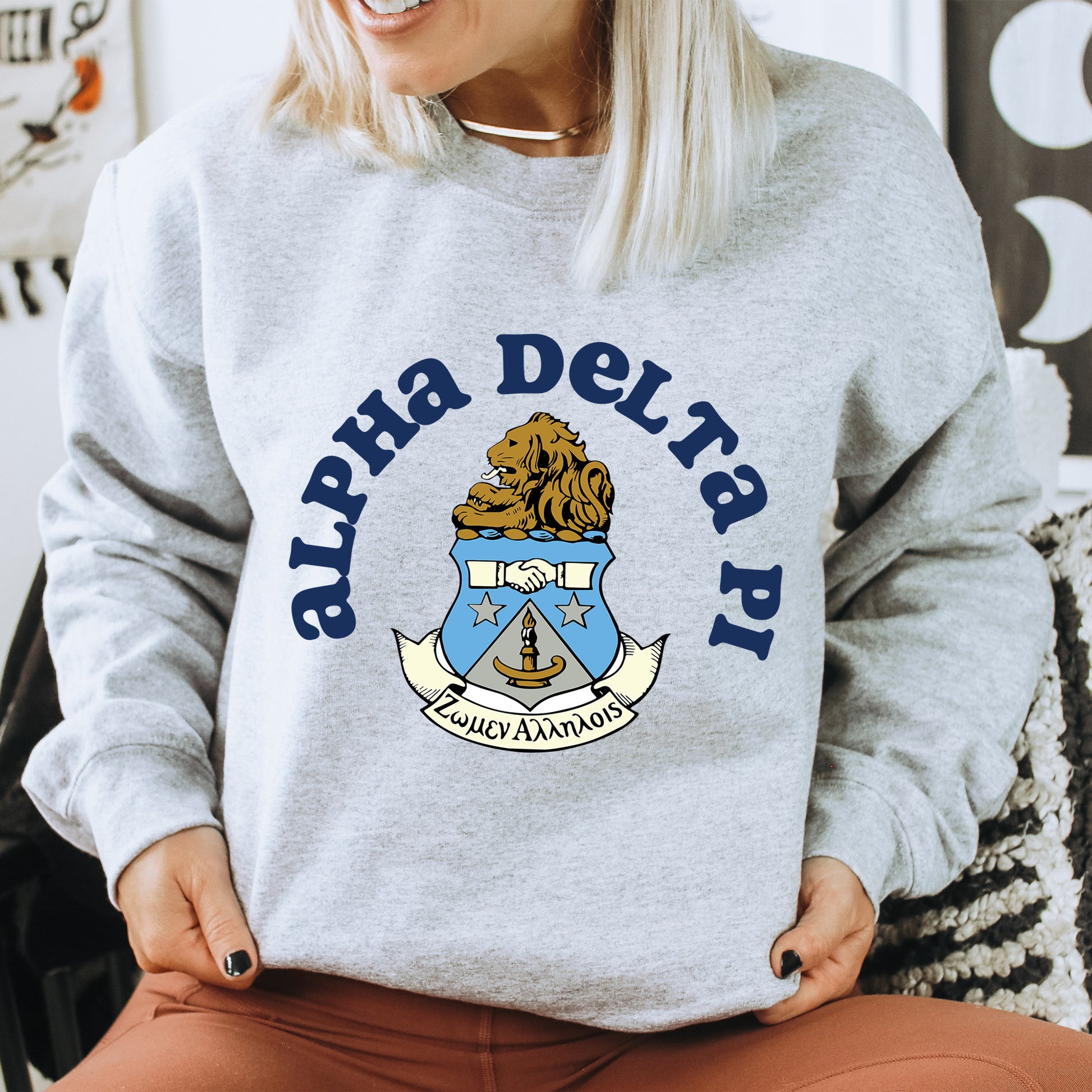 a woman sitting on a chair wearing a sweatshirt