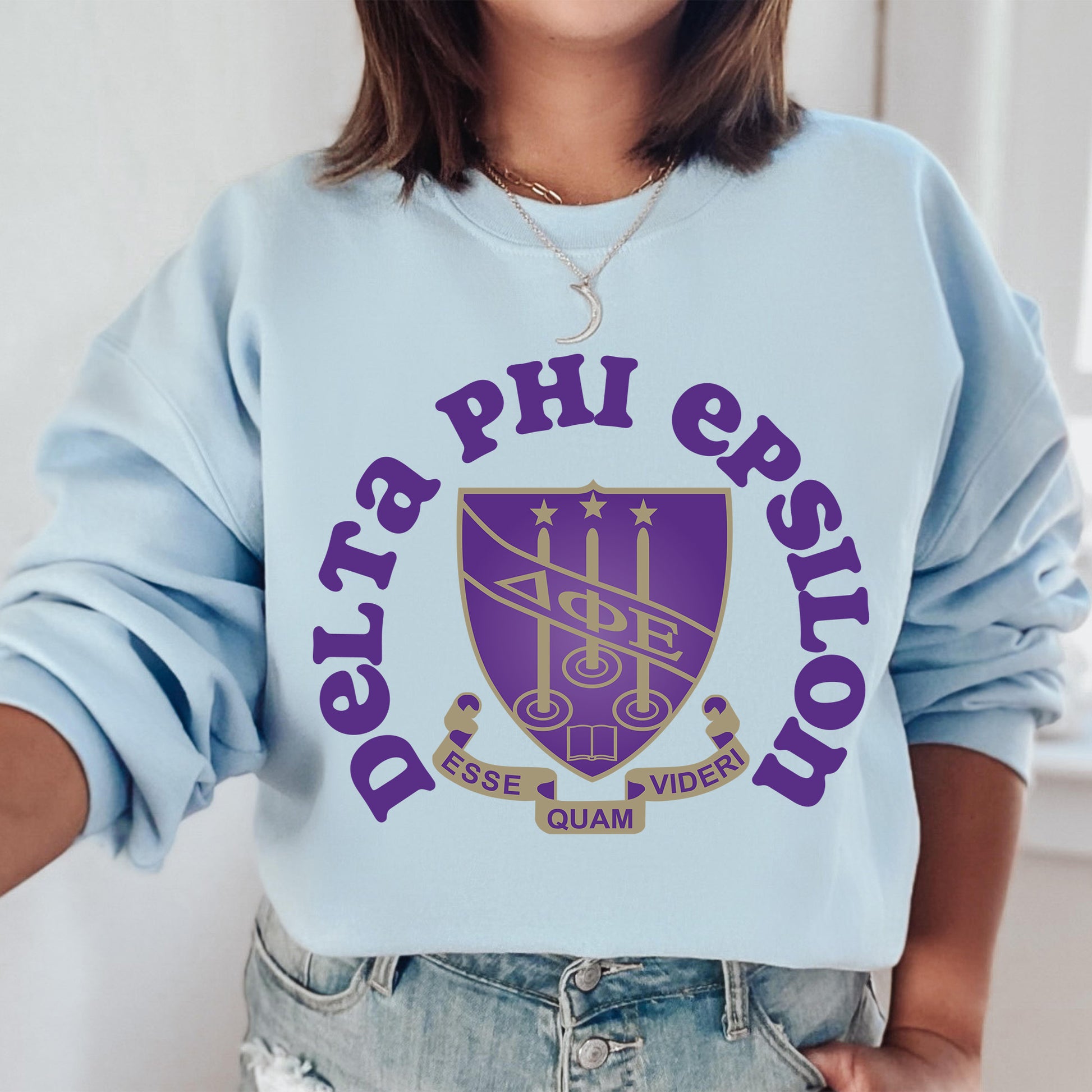 a woman wearing a blue sweatshirt with purple letters on it