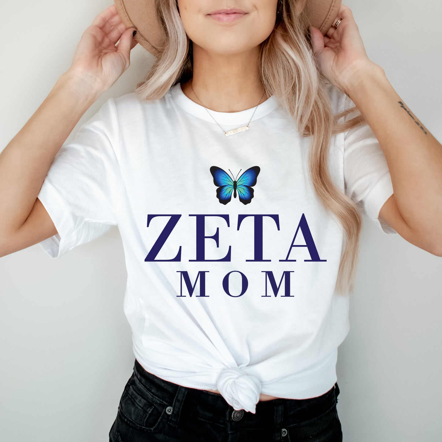 a woman wearing a white shirt with a blue butterfly on it