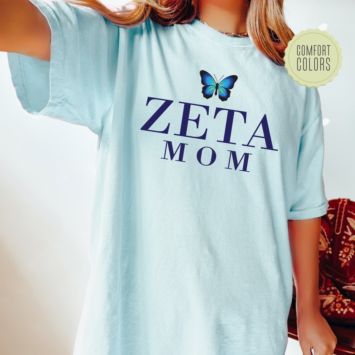 a woman wearing a blue shirt with a butterfly on it