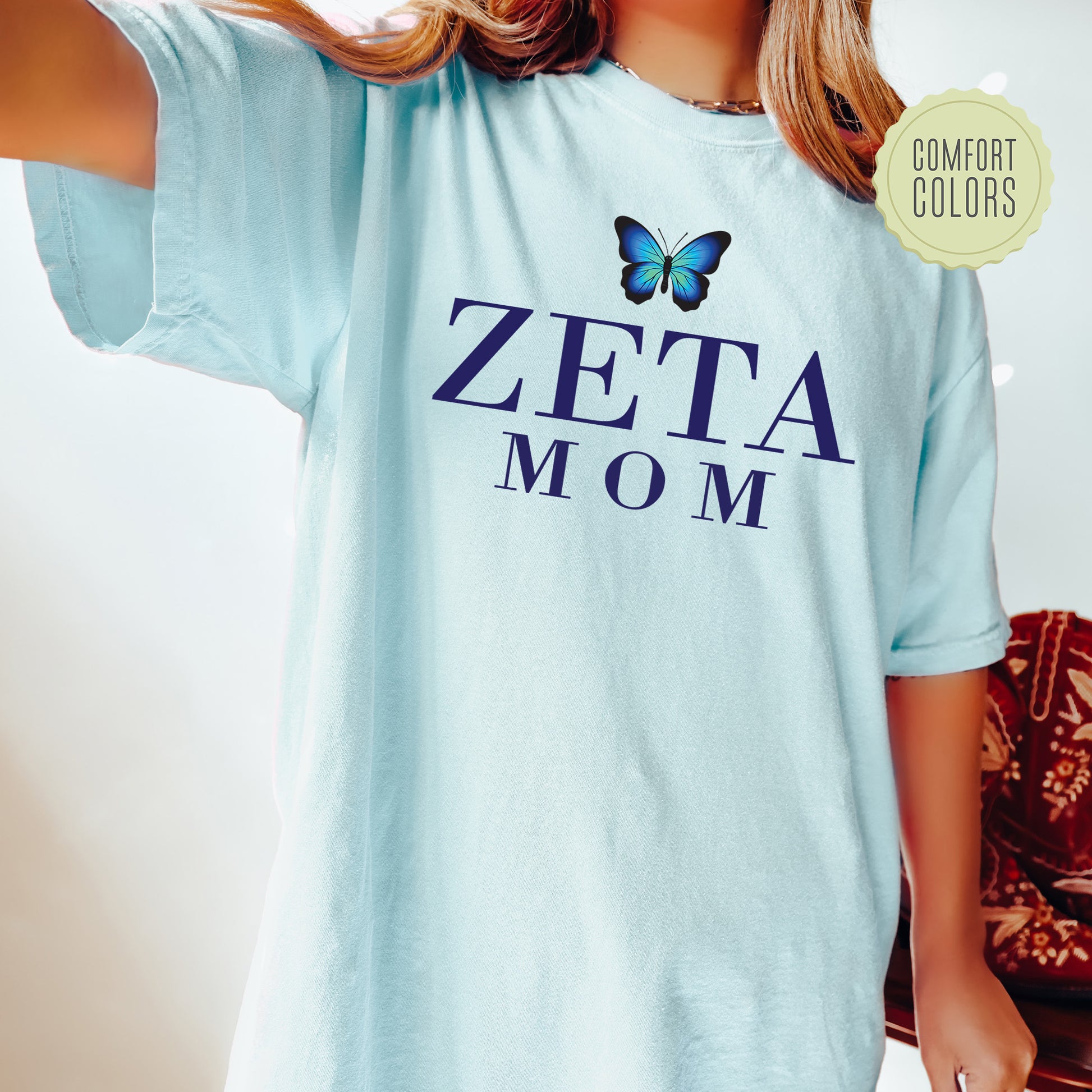 a woman wearing a blue shirt with a butterfly on it