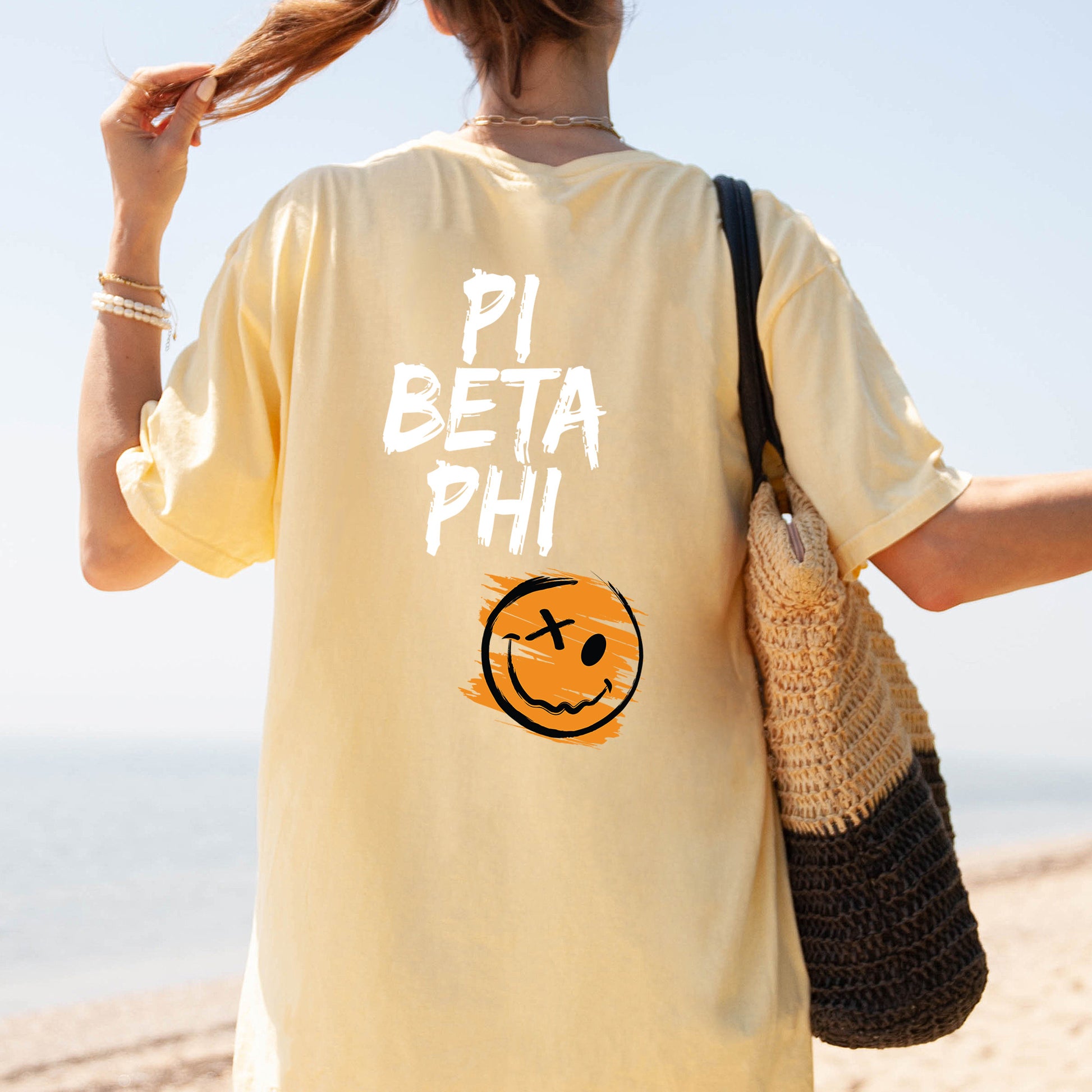 a woman is walking on the beach with a smile on her shirt